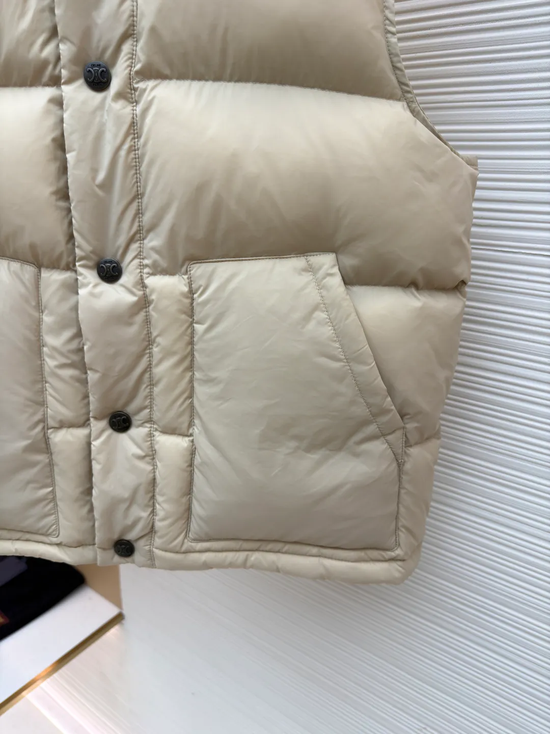 Celine lightweight sleeveless down jacket [Women's clothing] ●Item number: 1681072-C65 ●Fabric: Outer layer: nylon fabric; Inner layer: white duck down ●Technology: Mechanical down filling ●Version: Fitted version ●Weight: about 435 grams ●Size: 36-38-40 ●Description: The fabric is made of 100% nylon (nylon). Its high-density structure achieves excellent windproof effect. It also has strong wear resistance and wrinkle resistance. It is scratch-free for daily wear and can be easily taken care of. The inner lining is made of 100% polyamide, which has a smooth texture and further enhances wearing comfort and freedom of movement. The TRIOMPHE signature patch is carefully crafted with high-density foam padding and embroidery technology. Each embroidery trace is precise and neat, and the back is lined and hemmed to ensure neatness inside and outside, the stitches are even and fine, the three-dimensional relief texture lasts as new, and the extraordinary creative spirit is demonstrated in every detail. The lining is fully hemmed, and the seams are flat and smooth, eliminating friction. Quilting encryption technology is implemented in key parts to effectively prevent down displacement and ensure that it maintains a uniform and fluffy shape for long-term wear. TRIOMPHE custom-made snap buttons, each snap button is firmly stitched, opens and closes smoothly, taking into account both practical function and exquisite aesthetics. The ribbed wool high collar is woven with fine wool and has moderate elasticity. It can closely fit the curve of the neck, achieve windproofing and warmth without leaving gaps, and gently care for sensitive skin. White duck down has high down content and excellent fluffiness. It is filled with a scientific ratio of duck down and polyester fiber, and combines the efficient temperature-locking properties of duck down with the long-lasting support of polyester fiber to create a lightweight, non-sense yet warm and reliable thermal insulation system, making it easier to keep out the cold. The overall wiring is straight and delicate, the fabric is comfortable and soft, and the color is consistent without color difference. It can be matched with the same style to create a fashionable look and control various occasions. Customized accessories, complete with three standards, same style for men and women!