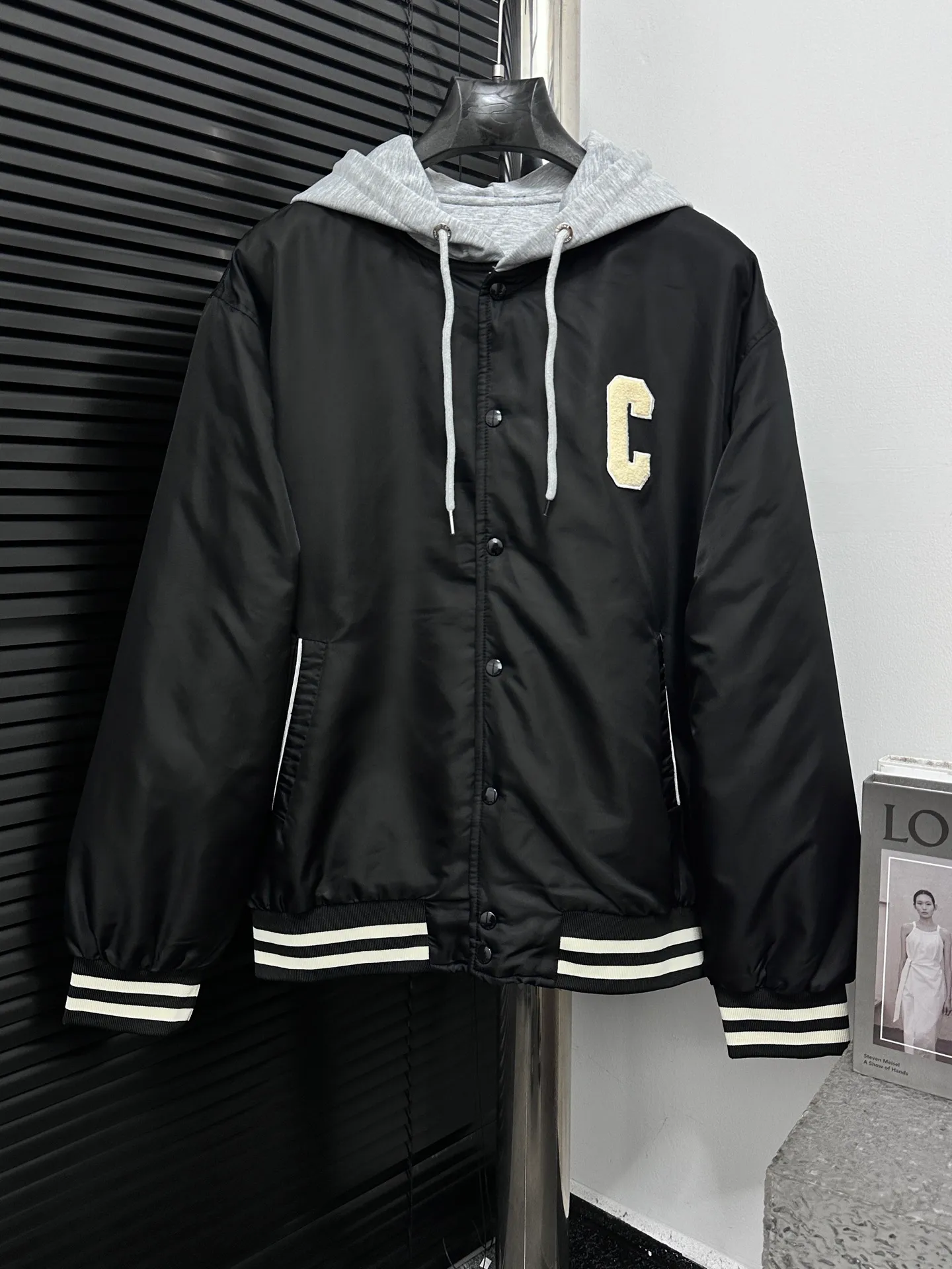 🅿️520 [Celine] Celine hooded baseball jacket, double fabric splicing: the outer black is satin technical fabric, and the front and back panels are customized with towel embroidery. The letters are first laser-cut and made using an imported Tajima embroidery machine. The hood and lining are made of 100% cotton fabric, with thin cotton inside, two-color thread custom-woven yarn, thread weaving on a flat knitting machine, and processed by first-line factories. Compare the quality at will. Same style for men and women. Size: XS-L