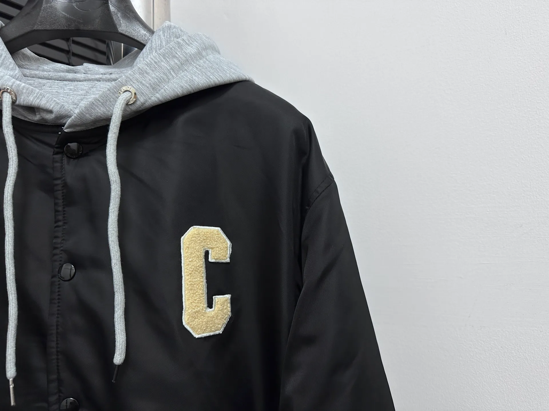 🅿️520 [Celine] Celine hooded baseball jacket, double fabric splicing: the outer black is satin technical fabric, and the front and back panels are customized with towel embroidery. The letters are first laser-cut and made using an imported Tajima embroidery machine. The hood and lining are made of 100% cotton fabric, with thin cotton inside, two-color thread custom-woven yarn, thread weaving on a flat knitting machine, and processed by first-line factories. Compare the quality at will. Same style for men and women. Size: XS-L