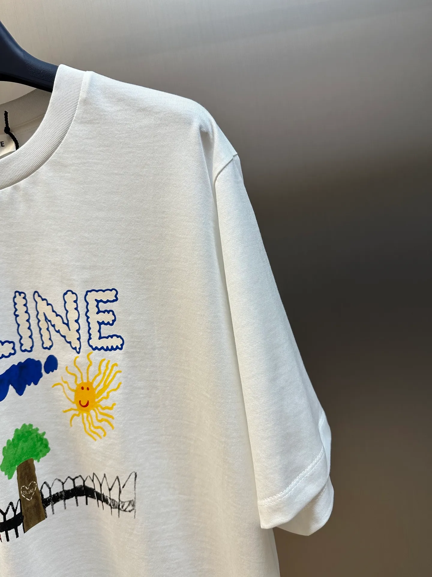 🅿️260 Celine childlike painting printed round neck short sleeves. Specific mercerized long-staple cotton fabric, made of 50S double-strand mercerized cotton, weight 165g; with 32S 1×1 tensioner thread, 300g. The finer the yarn and the higher the count, the softer, smoother and finer the resulting fabric is usually. Two yarns are used and twisted together. Doing so can enhance the strength and durability of the fabric and give it a fuller feel. Cotton fibers are treated with concentrated caustic soda solution to smooth the fiber surface and increase the gloss and softness of the fabric.  Childlike graffiti painting printing, according to the original color and the same color glue material, choose high-elastic stretch frame glue printing. It increases the elasticity of the printed area, and at the same time has strong penetration and color fastness, especially on cotton fabrics. The details of the printing are very well handled, with no burrs or traces of crossing the border. After technical processing of the printing screen, the slurry can penetrate into the fabric where there is a pattern. The permeability is strong and the fabric texture is clearly visible.  Dot paste printing technology is partially used. The distribution of dots is very dense, so the printed pattern has extremely high clarity and resolution. High-density dot paste printing technology is used to print various complex patterns and textures on clothing. Due to the special properties of the paste, the printed patterns have a certain degree of attraction, unique visual effects, and delicate touch.  Simple vertical round neck and short-sleeved version, the pattern is developed to create an extremely straight fit. The knitted material has certain stretchability, and the upper body will not be too tight. Round neck with ribbed splicing of the same color. The inner back collar is taped to effectively prevent the neckline from deforming after repeated wear and washing. The shoulder line is fitted, and the bottom hem and cuffs are trimmed with specially machined open-stitching.  size：xs s m l