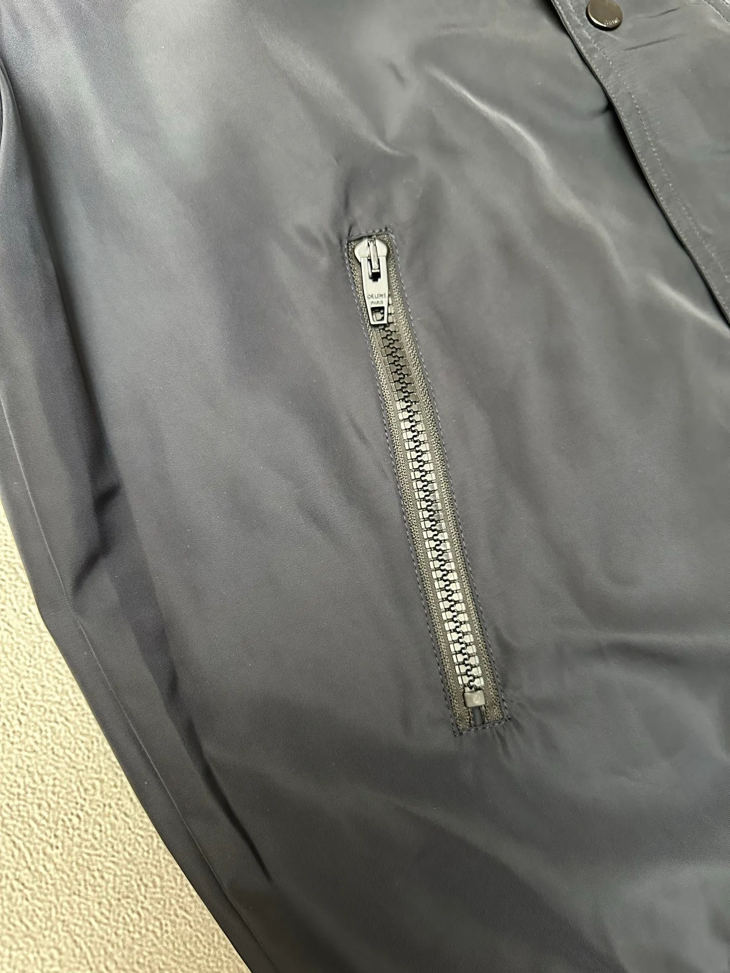 🅿️600 CELINE embroidered windbreaker Fabric selection: Oxford fabric made of 100% polyester fiber. The fiber properties have good toughness, and the lattice-like weave structure of Oxford cloth makes the fabric structure tight, very resistant to pulling and abrasion, and at the same time it has certain water-repellent properties. The density of polyester fiber itself is not high. While providing high strength, it maintains a relatively light weight and is easy to wear.  Technology: The computer embroidery machine is set to extremely high stitch density, and the fabric and backing are tightly fixed on the frame of the embroidery machine with even and just the right tension. The double-axis linear guide drives the embroidery frame, and the frame moving accuracy can reach 0.01mm/P, ensuring precise positioning and the embroidery pattern completely covering the base fabric.  The zipper and 6 snap-buttons engraved with CELINE provide double protection. Accessories: One-to-one customized snap-buttons, One-to-one customized elastic buckles, One-to-one customized zipper pullers, SIZE: 46 48 50 52