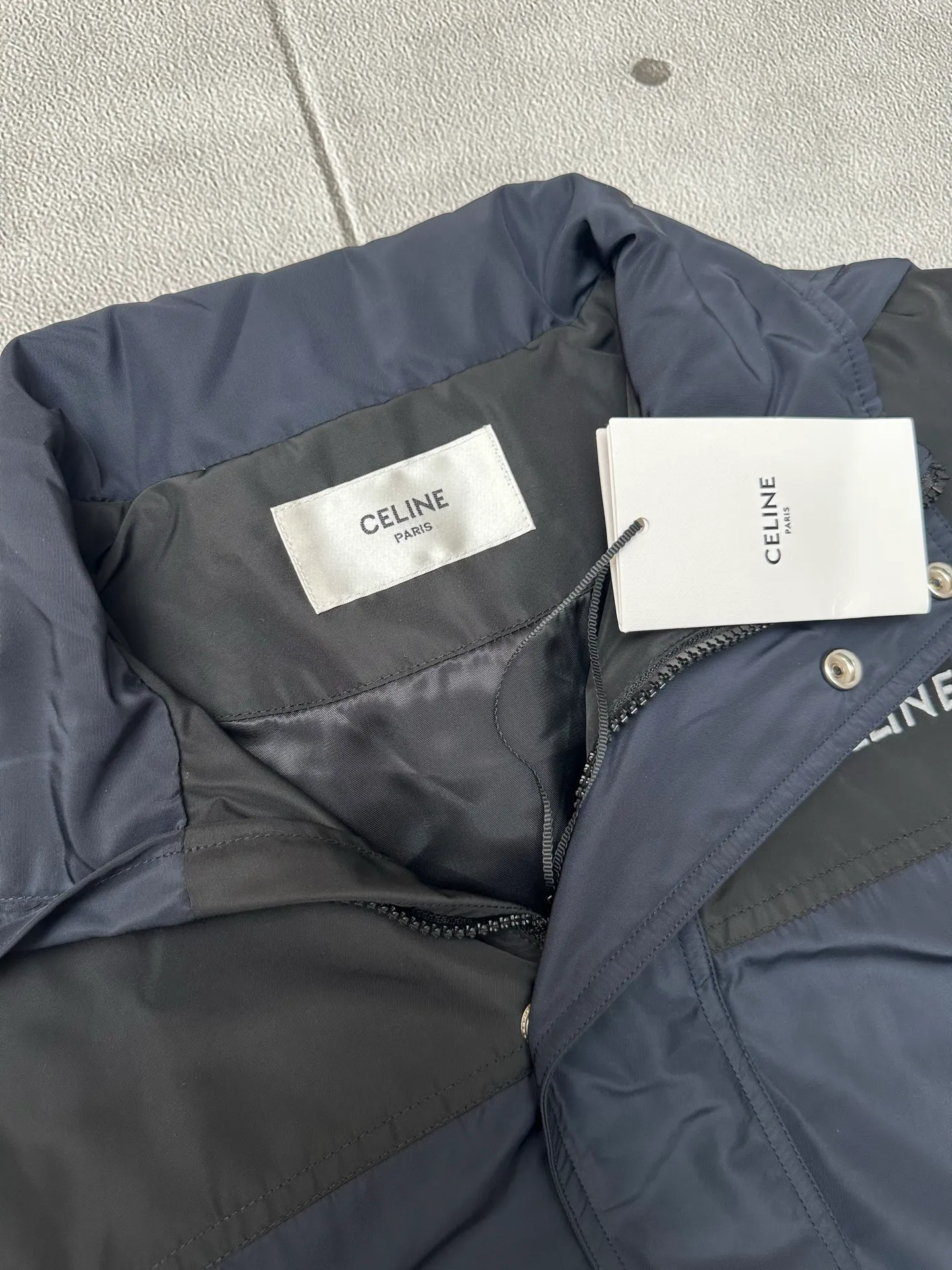 🅿️600 CELINE embroidered windbreaker Fabric selection: Oxford fabric made of 100% polyester fiber. The fiber properties have good toughness, and the lattice-like weave structure of Oxford cloth makes the fabric structure tight, very resistant to pulling and abrasion, and at the same time it has certain water-repellent properties. The density of polyester fiber itself is not high. While providing high strength, it maintains a relatively light weight and is easy to wear.  Technology: The computer embroidery machine is set to extremely high stitch density, and the fabric and backing are tightly fixed on the frame of the embroidery machine with even and just the right tension. The double-axis linear guide drives the embroidery frame, and the frame moving accuracy can reach 0.01mm/P, ensuring precise positioning and the embroidery pattern completely covering the base fabric.  The zipper and 6 snap-buttons engraved with CELINE provide double protection. Accessories: One-to-one customized snap-buttons, One-to-one customized elastic buckles, One-to-one customized zipper pullers, SIZE: 46 48 50 52