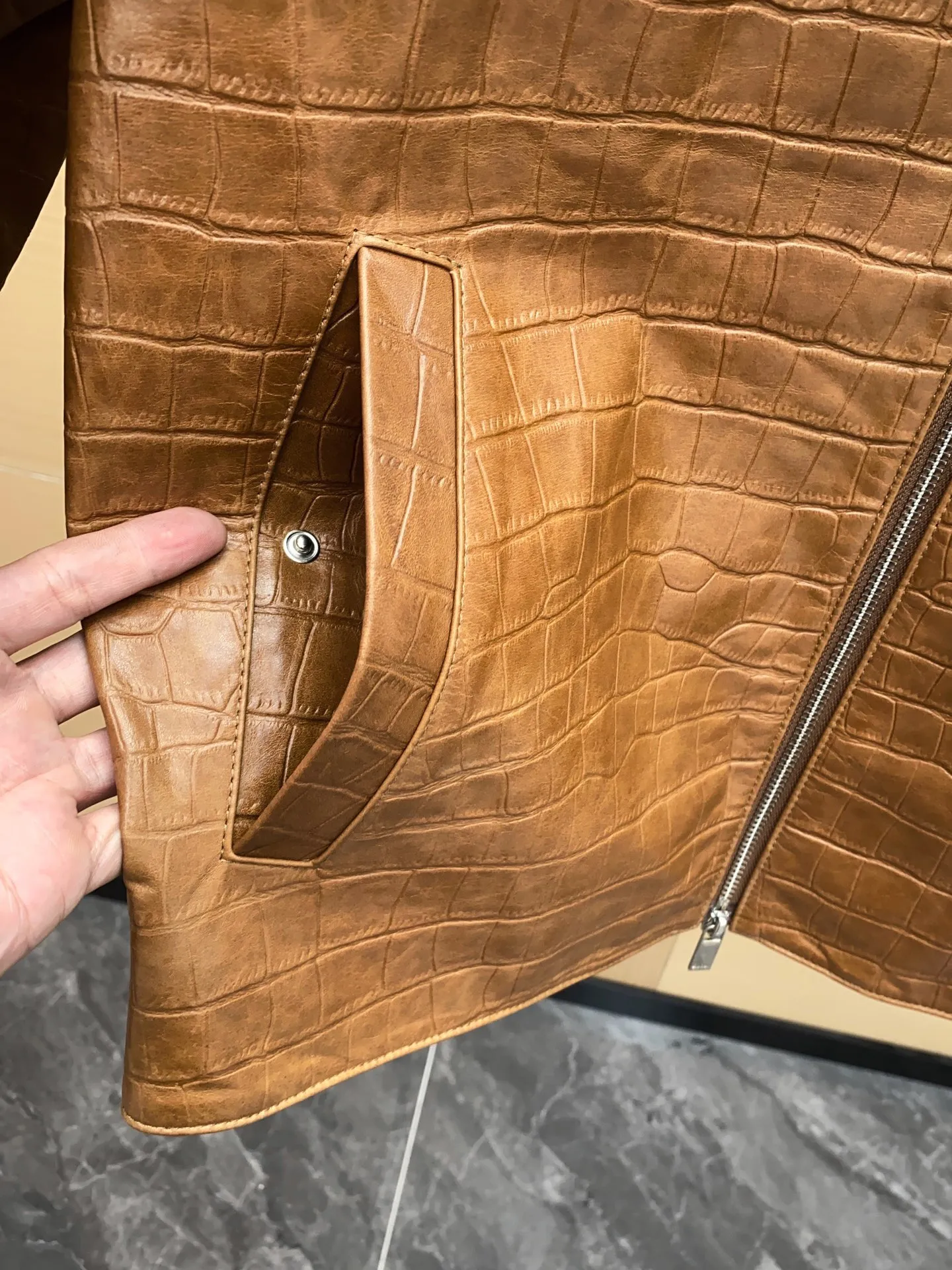 🅿️3060 DIOR Dior's new men's sheepskin jacket for autumn and winter 2025, reshaping autumn and winter style. On the fashion stage, Dior has always been the trend leader. In the autumn and winter of 2025, Dior's new men's sheepskin jacket makes a shocking debut, bringing the ultimate experience to men who pursue quality and style.   The jacket is made of imported brown sheepskin. Its unique color is deep and full of charm, like an elegant poem that has accumulated over time, highlighting the mature and stable temperament of men. This high-quality sheepskin not only looks charming, but also feels soft and delicate. Every time you touch it, you can feel the luxurious texture brought by the top material. It also has good breathability and wear resistance, ensuring that it is comfortable to wear in various occasions.   The design with crocodile print all over the body is the finishing touch. The crocodile pattern symbolizes strength and wildness, injecting unique fashion tension into the jacket, making the wearer stand out from the crowd. Every texture has been carefully suppressed, delicate and clear, showing a lifelike three-dimensional effect, interpreting Dior's persistent pursuit of craftsmanship.   The short version is a precise grasp of modern fashion. It breaks the traditional constraints and cleverly optimizes body proportions. Even men with average figures can instantly have a tall and straight posture when wearing it, showing a neat and capable temperament. Whether it is paired with a simple white T-shirt and jeans for casual daily use, or worn with a shirt and trousers for a business event, it can be perfectly adapted and can easily handle various occasions.   The new products of the season have arrived in the store. We sincerely invite you to try them out and experience the unique charm of Dior's new 2025 autumn and winter men's sheepskin jackets.  Code number: 48-56