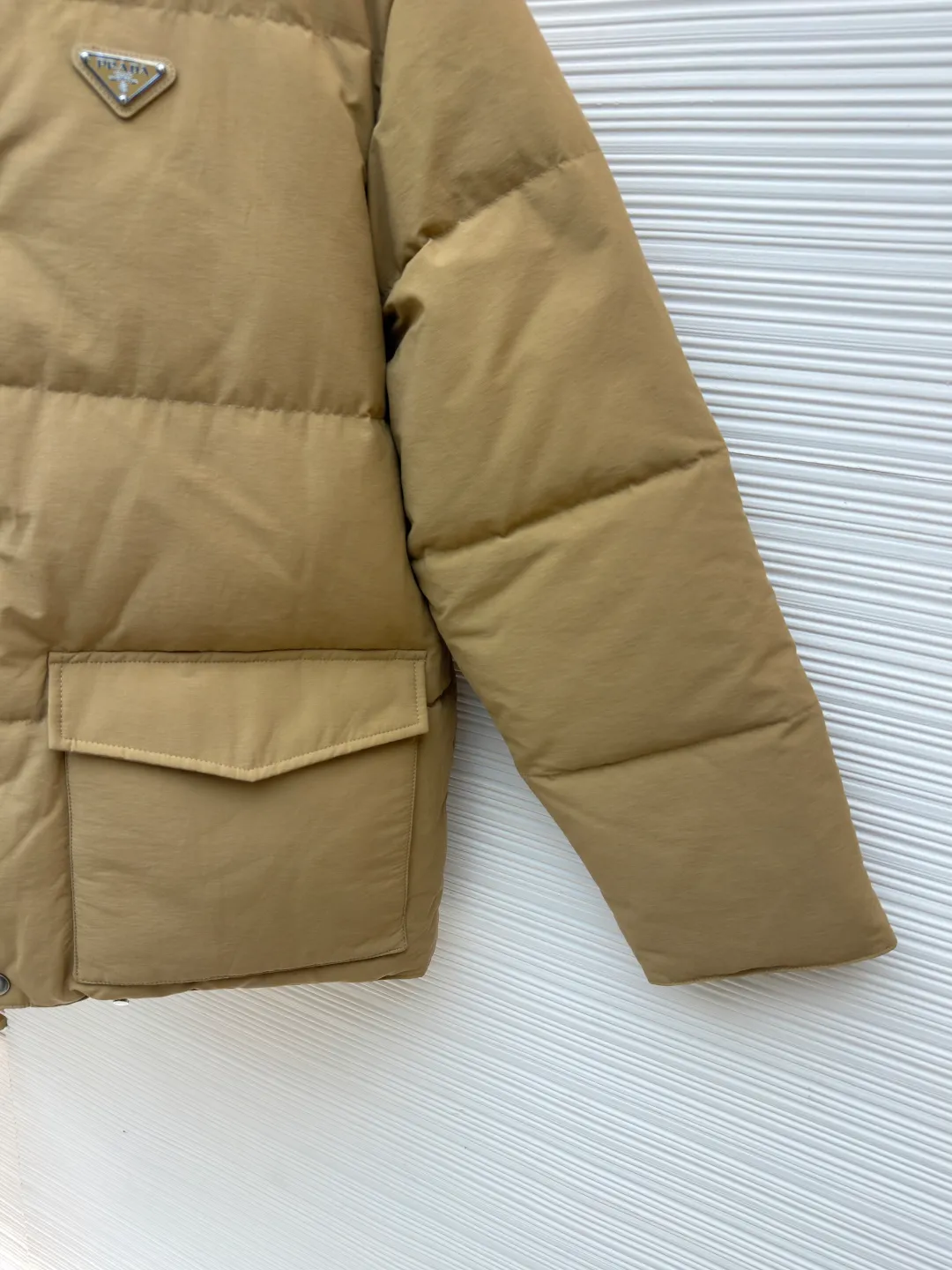 Prada triangle logo basic down jacket ●Original version: purchased and developed by 23122 ●Item number: 1681860-D15 ●Fabric: white duck down fabric ●Technology: mechanical down filling ●Color: khaki ●Version: fitted version ●Weight: about 1860 grams ●Size: S-M-L-XL ●Description: It is made of extremely fine nylon yarn and is woven in a high-density manner. The number of yarns per unit area is large, and the gaps between the yarns are very small, which can effectively block the penetration of cold wind. The fine weave keeps it lightweight and soft to the touch, physically restricting the lightweight down fibers from slipping through the gaps. Nylon fiber itself has good wear resistance and is not easy to snag, which significantly extends its service life and can easily cope with the needs of multiple scenarios. The lining is made of high-density weaving of 100% polyester fiber, with a thickness of 0.08mm to avoid increasing the overall weight and making it smooth to wear. The high-density weaving structure forms a wind resistance layer to protect the thermal efficiency of the thermal layer from loss. It can withstand the expansion pressure of down and prevent deformation and damage after long-term use. Each buckle is suspended independently, and in the carefully controlled current and solution, a 360-degree uniform coating without dead ends is achieved, which has stronger wear resistance and corrosion resistance. The interior is filled with 90% of the new national standard white duck down, with a filling capacity of up to 280 grams. The down is full and fluffy, and has excellent temperature locking performance. It is light and weightless, but can withstand the cold wind, making walking in winter as smooth as spring. The overall wiring is straight and delicate, the fabric is comfortable and soft, and the color is consistent without color difference. It can be matched with the same style to create a fashionable look and control various occasions. Customized accessories, complete with three standards, same style for men and women!
