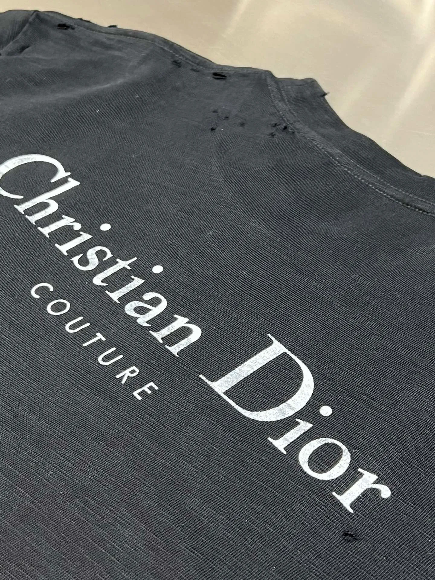 🅿️330 Dior ripped letter print short sleeves The fabric is made of 10s pure cotton slub plain fabric with a weight of 310g. This fabric is used as the collar, and the round collar is manually positioned on a flat machine. The front and back panels are printed with hand-made platen silk screen glue, and the film is engraved with laser dots to create a hollowed-out effect of missing letters. The clothes are designed with bifurcated sides, and the hems of the front and rear panels are cut with a special machine to pick the legs. There are lines on the surface to create a hollow effect. The entire garment is manually positioned and cut with holes, and the garment is fermented and washed to create a nostalgic effect. size：xs s m l