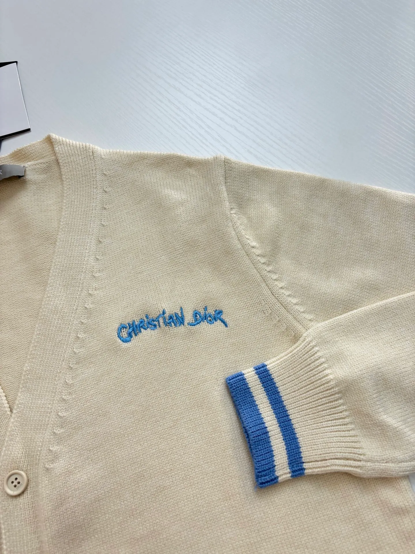 🅿️460 Dio*/Dior 25FW letter embroidered cardigan sweater is made of 70 wool, 30 camel hair blended 40 count double-ply yarn to carry the ball. The pattern-spun yarn is custom-dyed in beige and apricot colors, and an imported 12-needle knitting machine is used for the plain weave process. The chest is decorated with a classic logo on the front. The letter pattern is embroidered with imported Tajima machines using thousands of needles. It adopts precise needle embroidery technology. The embroidery is very fine and dense, and the letter pattern outlines the design clearly. Double-sided wool hanging technology, fine workmanship, clear texture and texture, and extremely fine woven threads are made of environmentally friendly fibers. Combined with the special soft washing process, the body fabric has a soft touch. The softly stretched environmentally friendly microfiber creates the bottom layer, which is not easily deformed when stretched, and still maintains the original wide feeling. Customized natural resin engraved buttons, complete with three-label accessories, same style for men and women.  Size：S/M/L