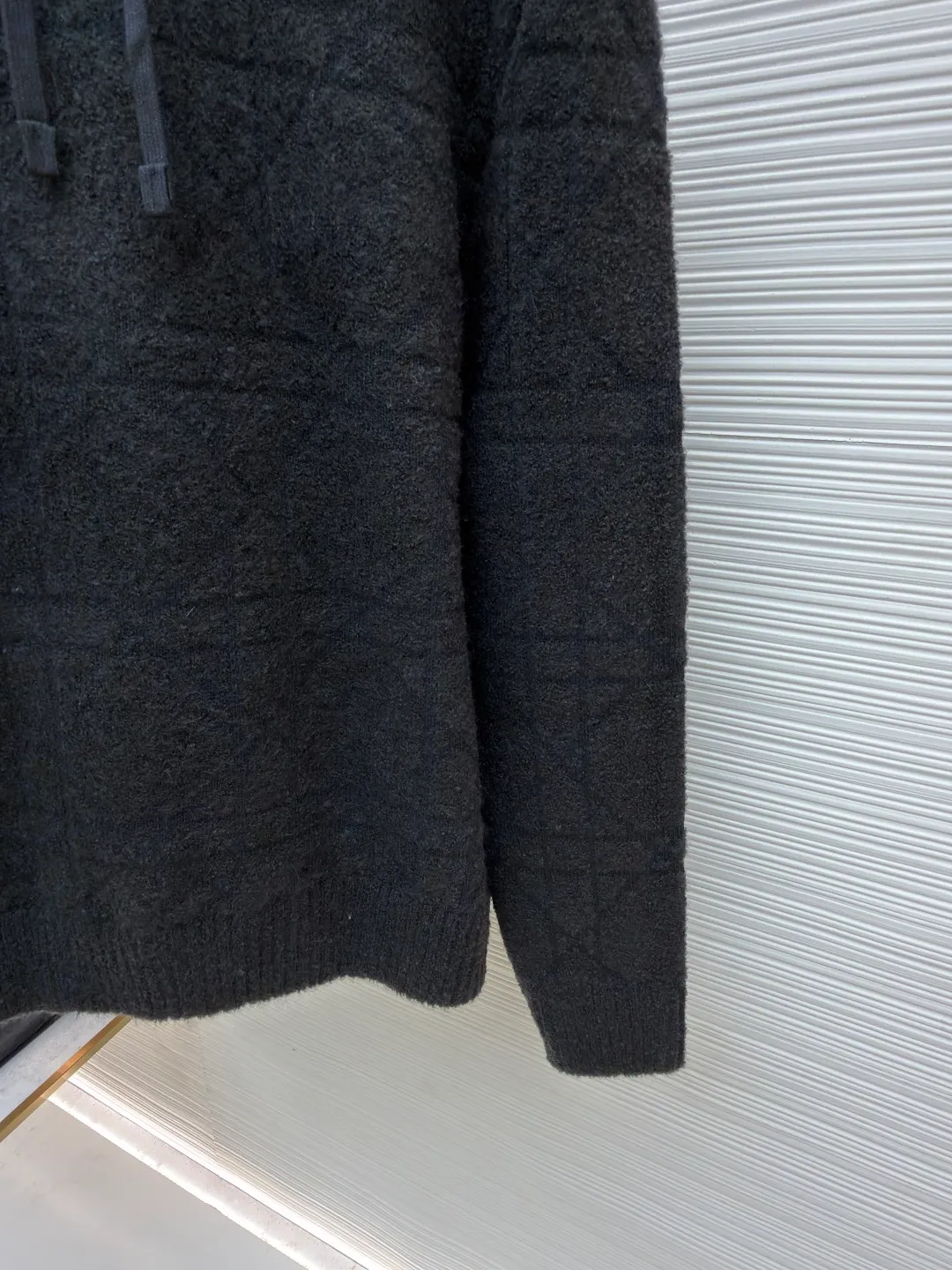 Dior diamond pattern jacquard knitted hoodie ●Original version: 24000 purchased and developed ●Item number: 1681969-C10 ●Fabric: wool blended fabric ●Technology: jacquard knitting ●Color: black ●Version: fitted version ●Weight: about 1415 grams ●Size: XS-S-M-L ●Description: This is LV The 2025 autumn and winter series of plush hooded sweaters are made of 100% Albaka wool blend, and the yarn contains 30% alpaca. It is woven with a 16-needle coarse weaving process. The surface presents a matte plush texture and is twice as warm as ordinary wool. The main body of the garment is made of rhombus plaid jacquard, with a three-dimensional texture formed by alternating front and back stitching techniques without additional seams. The hood is made of one-piece knitting, with an invisible shaping lining built into the brim, making it more comfortable to wear. The drawstring is made of core-spun rope of the same material, and the rope ends are treated with metal crimping, making it durable and not easy to wear. The finished product is ironed with low-temperature steam to avoid damage to the plush fibers. The cuffs and hem are ribbed for long-lasting elasticity and a good fit. The whole piece is sewn in an Italian workshop, with no exposed threads in the details, continuing the exquisite standards of the brand's high-end knitted items. The overall stitching is straight and delicate, the fabric is comfortable and soft, and the color is consistent with no color difference. It can be matched with the same style to create a fashionable look and control various occasions. Customized accessories, complete with three standards, the same style for men and women!