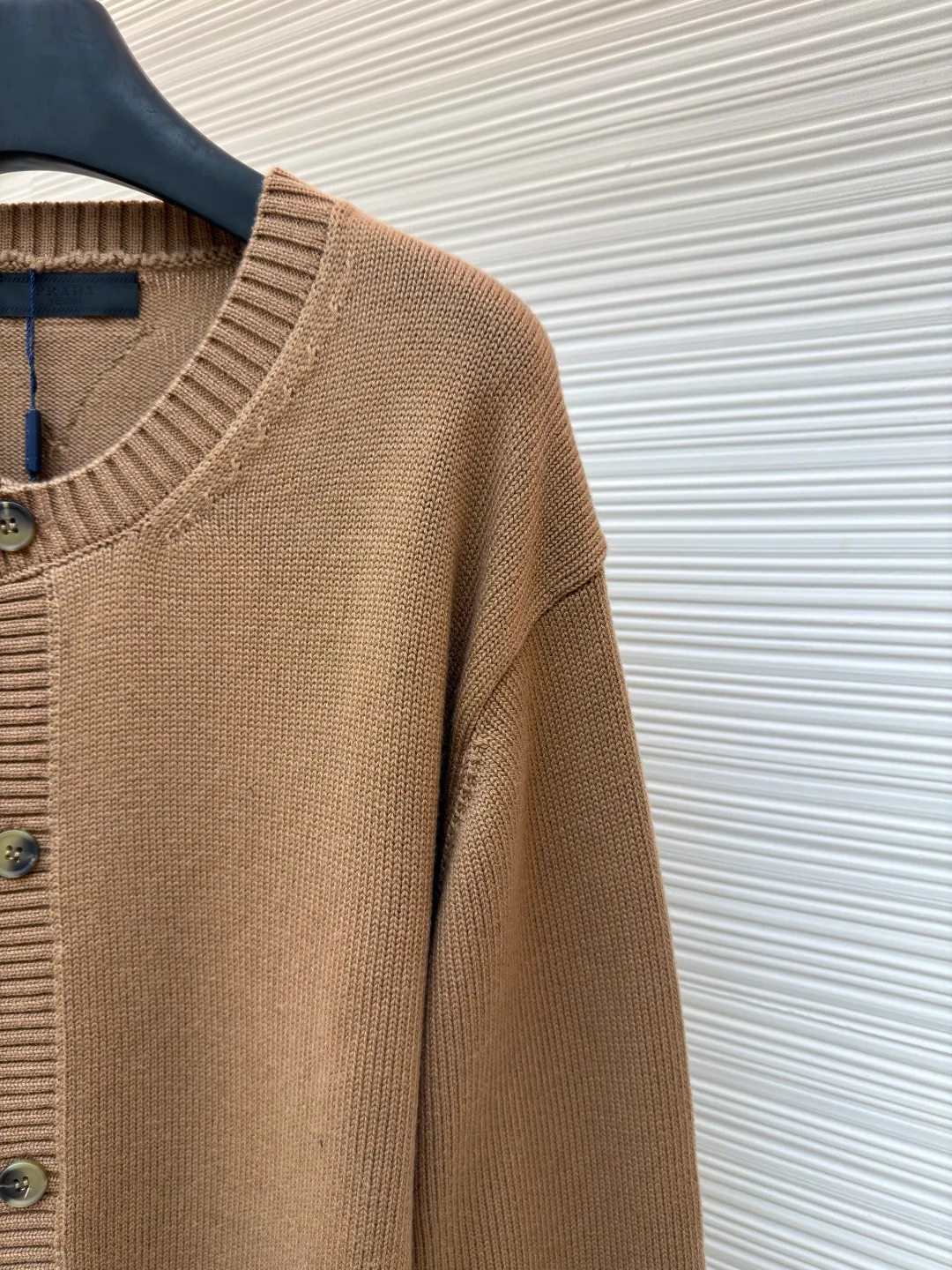 Prada round neck single-breasted cashmere cardigan ●Original version: Purchased and developed by 10189 ●Item number: 1681575-A85 ●Fabric: wool blended fabric ●Technology: knitted ●Color: camel ●Version: Fitted version ●Weight: about 830 grams ●Size: S-M-L-XL ●Description: This knitted cardigan is made of high-quality wool blended fabric, with a soft and delicate feel and excellent warmth retention properties. The body features a classic round neck design for a comfortable fit. The front placket is closed with a single-breasted button, making it easy to put on and take off and look neat. There are symmetrical pockets on both sides, which are practical and enhance the overall look. The knitted texture is clear and even, demonstrating exquisite craftsmanship. Ready-made garments undergo strict quality inspection to ensure that each piece meets high standards. Whether worn with a shirt or a T-shirt, this cardigan can show its unique fashion taste and texture. The overall wiring is straight and delicate, the fabric is comfortable and soft, and the color is consistent without color difference. It can be matched with the same style to create a fashionable look and control various occasions. Customized accessories, complete with three standards, same style for men and women!
