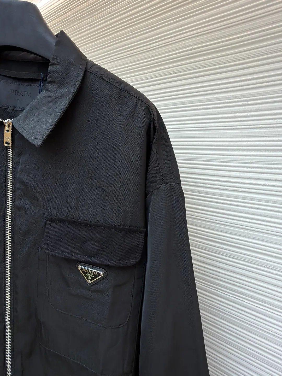 Prada solid color logo zipper lapel long-sleeved jacket ●Original version: purchased and developed by 7262 ●Item number: 1681635-B05 ●Fabric: nylon twill high-count and high-density windbreaker fabric ●Technology: Positioned cutting machine production ●Color: black ●Version: fitted version ●Weight: about 465 grams ●Size: S-M-L-XL ●Description: This Prada jacket is made of high-quality waterproof and windproof fabric, which feels crisp and breathable. The three-dimensional tailoring fits the body shape, and the lapel design with smooth zipper closure makes it neat and stylish to wear. The brand triangle metal logo on the chest highlights the brand identity, and the details are exquisite. The body of the garment has a rigorous structure, and the splicing uses flat-turn open-stitching technology. The stitches are even and flat, and the lines are clear and smooth. The pocket design is practical and beautiful, and the edges are reinforced to ensure durability. The elastic hems on the hem and cuffs are windproof, warm and flattering. The entire jacket embodies Prada's ultimate pursuit of quality and craftsmanship from fabric selection, tailoring to detail processing. It not only retains the elegant style of classic items, but also incorporates modern design language, making it suitable for a variety of occasions. The overall wiring is straight and delicate, the fabric is comfortable and soft, and the color is consistent without color difference. It can be matched with the same style to create a fashionable look and control various occasions. Customized accessories, complete with three standards, same style for men and women!