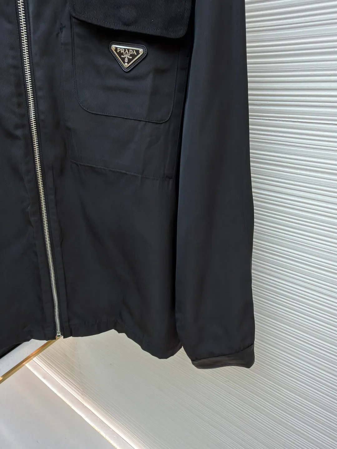 Prada solid color logo zipper lapel long-sleeved jacket ●Original version: purchased and developed by 7262 ●Item number: 1681635-B05 ●Fabric: nylon twill high-count and high-density windbreaker fabric ●Technology: Positioned cutting machine production ●Color: black ●Version: fitted version ●Weight: about 465 grams ●Size: S-M-L-XL ●Description: This Prada jacket is made of high-quality waterproof and windproof fabric, which feels crisp and breathable. The three-dimensional tailoring fits the body shape, and the lapel design with smooth zipper closure makes it neat and stylish to wear. The brand triangle metal logo on the chest highlights the brand identity, and the details are exquisite. The body of the garment has a rigorous structure, and the splicing uses flat-turn open-stitching technology. The stitches are even and flat, and the lines are clear and smooth. The pocket design is practical and beautiful, and the edges are reinforced to ensure durability. The elastic hems on the hem and cuffs are windproof, warm and flattering. The entire jacket embodies Prada's ultimate pursuit of quality and craftsmanship from fabric selection, tailoring to detail processing. It not only retains the elegant style of classic items, but also incorporates modern design language, making it suitable for a variety of occasions. The overall wiring is straight and delicate, the fabric is comfortable and soft, and the color is consistent without color difference. It can be matched with the same style to create a fashionable look and control various occasions. Customized accessories, complete with three standards, same style for men and women!