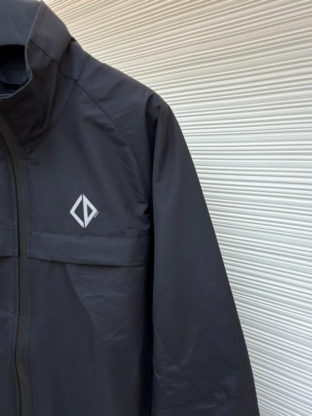 Dior Diamond logo reflective jacket ●Original version: Purchased and developed for 38000 ●Item number: 1681165-B65 ●Fabric: Obsidian intelligent laminated technical silk fabric ●Technology: Fluid laminated production ●Color: black ●Version: Fitted version ●Weight: about 560 grams ●Size: 44-46-48-50 ●Description: Customized Obsidian intelligent laminated technical silk, impermeable to wind and rain. It does not stagnate with sweat. Three-proof barrier. Excellent texture. It is based on pure black, setting a versatile tone. The front Dior Diamond logo is presented in a simple and exquisite form, which complements the eye-catching trimmed Dior logo on the back. When the light falls, it instantly blooms brightly. Between order and function, it builds a minimalist protective aesthetic and dynamic elegance, interpreting a new realm of sports aesthetics with a pioneering attitude. Infrared positioning heat transfer process Infrared positioning CD Diamond position is more accurate Use thermal transfer materials for processing Bake the fabric to fix the printing pattern Add fluorescent powder during the offset printing process Let creativity and inspiration shine, fluid lamination process Liquid glue strips are shaped by condensation Form invisible fluid sealing lines at fabric seams Gradient glue volume technology is used in three-dimensional folds and waterproof sealing Functionality and aesthetics symbiosis, template machine opens the bag Preset templates guide the position, shape and size of the bag opening Accuracy ensures the quality of bag opening results. The overall wiring is straight and delicate, the fabric is comfortable and soft, and the color is consistent without color difference. It can be matched with the same style to create a fashionable look and control various occasions. Customized accessories, complete with three standards, same style for men and women!