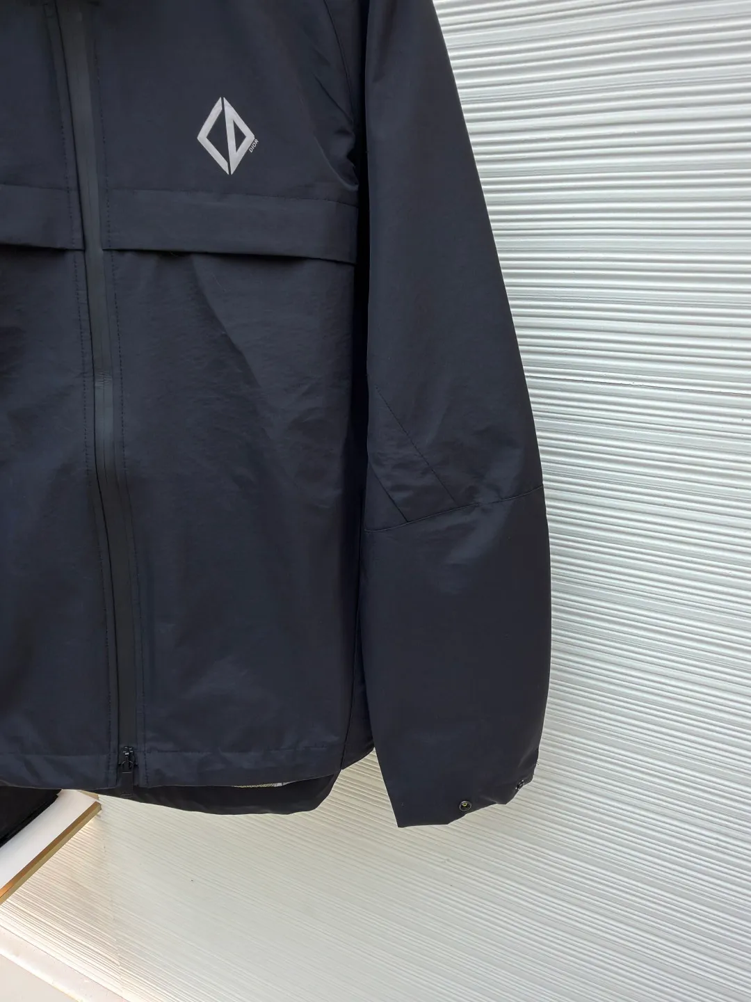 Dior Diamond logo reflective jacket ●Original version: Purchased and developed for 38000 ●Item number: 1681165-B65 ●Fabric: Obsidian intelligent laminated technical silk fabric ●Technology: Fluid laminated production ●Color: black ●Version: Fitted version ●Weight: about 560 grams ●Size: 44-46-48-50 ●Description: Customized Obsidian intelligent laminated technical silk, impermeable to wind and rain. It does not stagnate with sweat. Three-proof barrier. Excellent texture. It is based on pure black, setting a versatile tone. The front Dior Diamond logo is presented in a simple and exquisite form, which complements the eye-catching trimmed Dior logo on the back. When the light falls, it instantly blooms brightly. Between order and function, it builds a minimalist protective aesthetic and dynamic elegance, interpreting a new realm of sports aesthetics with a pioneering attitude. Infrared positioning heat transfer process Infrared positioning CD Diamond position is more accurate Use thermal transfer materials for processing Bake the fabric to fix the printing pattern Add fluorescent powder during the offset printing process Let creativity and inspiration shine, fluid lamination process Liquid glue strips are shaped by condensation Form invisible fluid sealing lines at fabric seams Gradient glue volume technology is used in three-dimensional folds and waterproof sealing Functionality and aesthetics symbiosis, template machine opens the bag Preset templates guide the position, shape and size of the bag opening Accuracy ensures the quality of bag opening results. The overall wiring is straight and delicate, the fabric is comfortable and soft, and the color is consistent without color difference. It can be matched with the same style to create a fashionable look and control various occasions. Customized accessories, complete with three standards, same style for men and women!