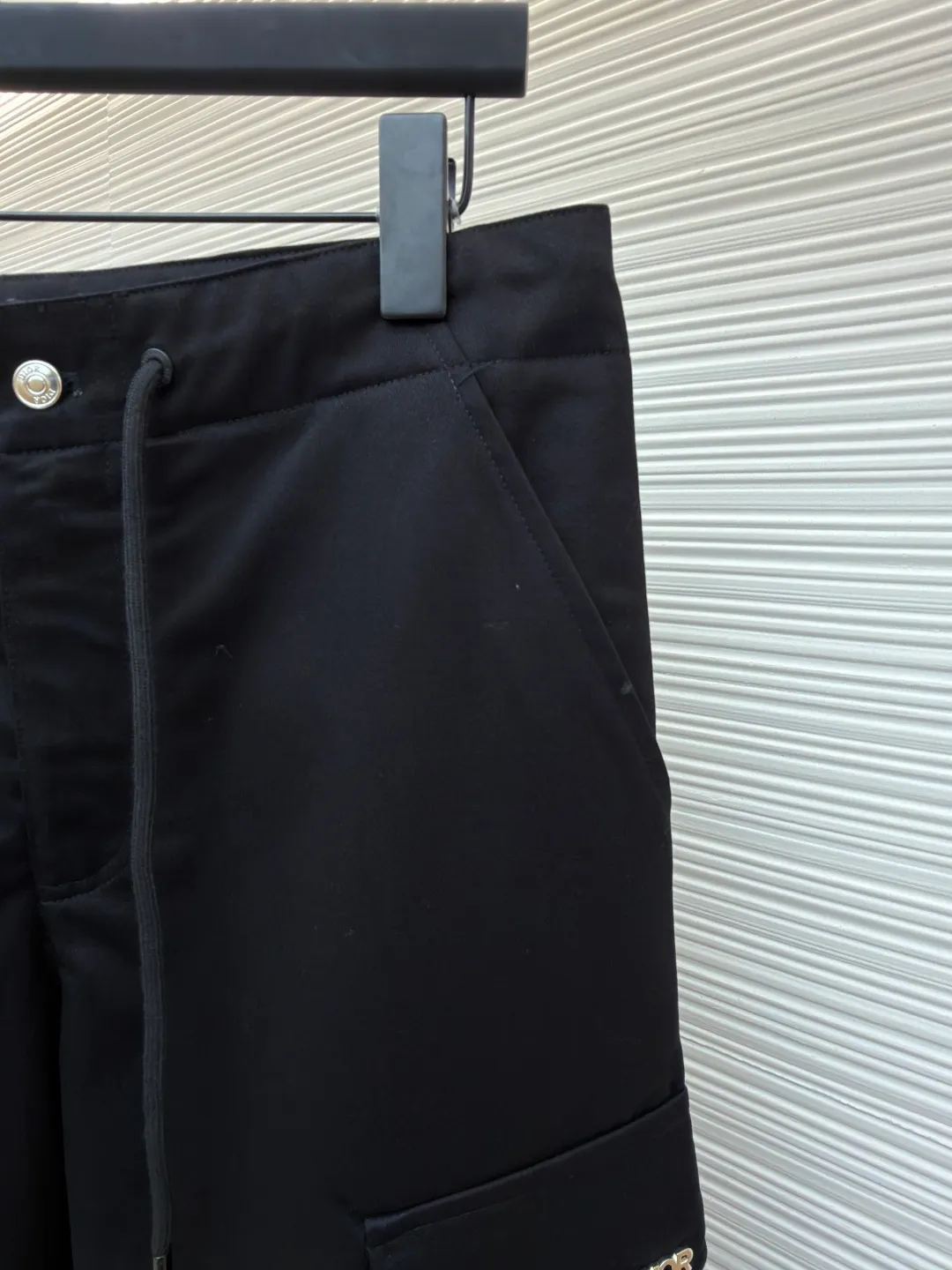 Dior cotton Huardani overalls ●Original version: purchased and developed for 11000 ●Item number: 1682108-B05 ●Fabric: cotton fabric ●Technology: made on positioning cutting machine ●Color: black ●Version: fitted version ●Weight: about 535 grams ●Size: 46-48-50-52-54-56 ●Description: These Dior black work casual pants are made of high-density twill blended fabric. The fabric has been treated with anti-static and water-repellent treatments. It feels crisp and not easy to pill and deform, and has a good drape feeling. The waistband of the trousers is designed with a double adjustment of drawstrings and metal snaps. The drawstring is a braided rope belt of the same color, and the metal snaps are treated with polished nickel plating, which has a long-lasting gloss and is not easy to oxidize. The side utility pockets are made of three-dimensional tailoring and splicing. The edges of the pocket are reinforced with double stitching. The body of the bag is inlaid with metal letter logos. It is made by laser engraving and electroplating processes. The fonts are clear and delicate. The seams on the trousers body are all overlocked, with cross-reinforced stitching on the crotch, hems on the trousers, and the overall cut is a straight workwear silhouette. Every structural splice has been accurately patterned, and the overall alignment is straight and delicate. The fabric is comfortable and soft, and the color is consistent without color difference. It can be matched with the same style to create a fashionable look and control various occasions. Customized accessories, complete three standards, the same style for men and women!