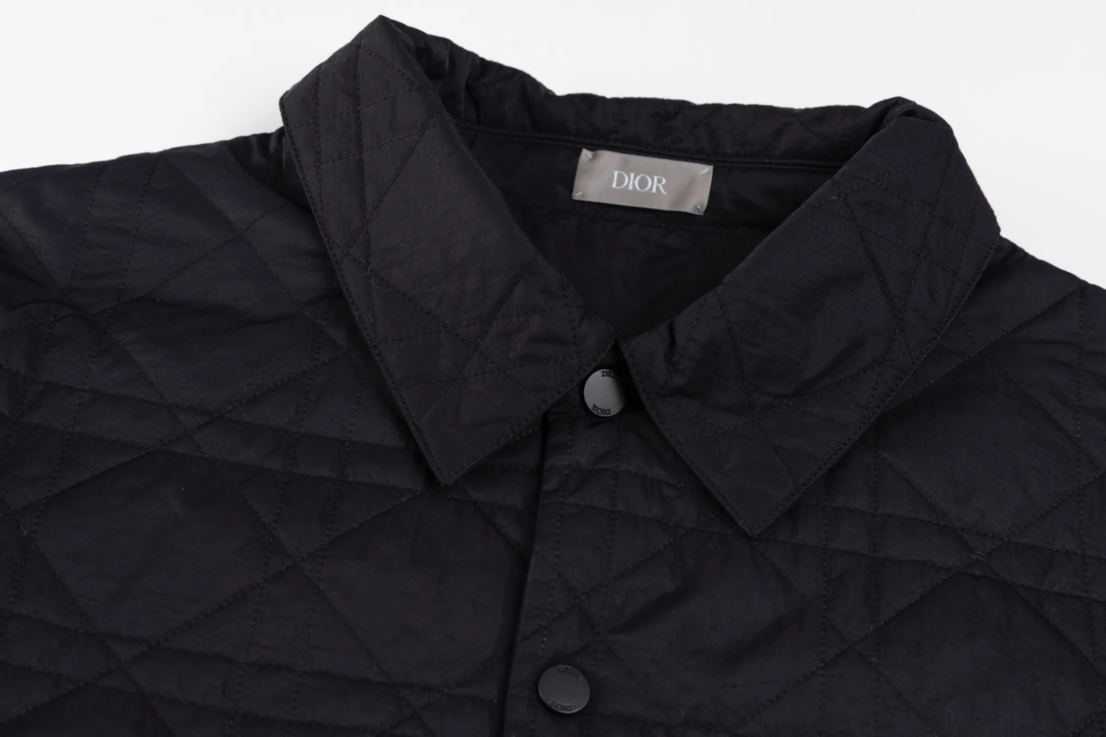 🅿️720 [Exclusive supply] CD Cannage nameplate embroidered jacket. The original version was purchased for 23,000 and developed. The fabric is made of polyester fiber technical fabric, which has both light texture and crisp silhouette. The whole body is quilted in the same tone to present the brand's iconic cannage pattern, and the details are full of exquisite craftsmanship. The chest patch pocket is decorated with an embroidered Christian Dior Couture logo, highlighting the brand's DNA. Side slits and metal snaps engraved with the Dior logo allow you to adjust the style of wearing. The overall tailoring is neat and smooth, perfectly combining traditional quilting technology with modern technological fabrics. The black tone presents a low-key luxury feel, and the cannage quilting lines are delicate and even, showing the craftsmanship of high-end ready-to-wear. This piece can be worn open for a casual style, or fastened with snaps for a slim fit, making it perfect for a variety of dressing scenarios. Size:46/48/50/52