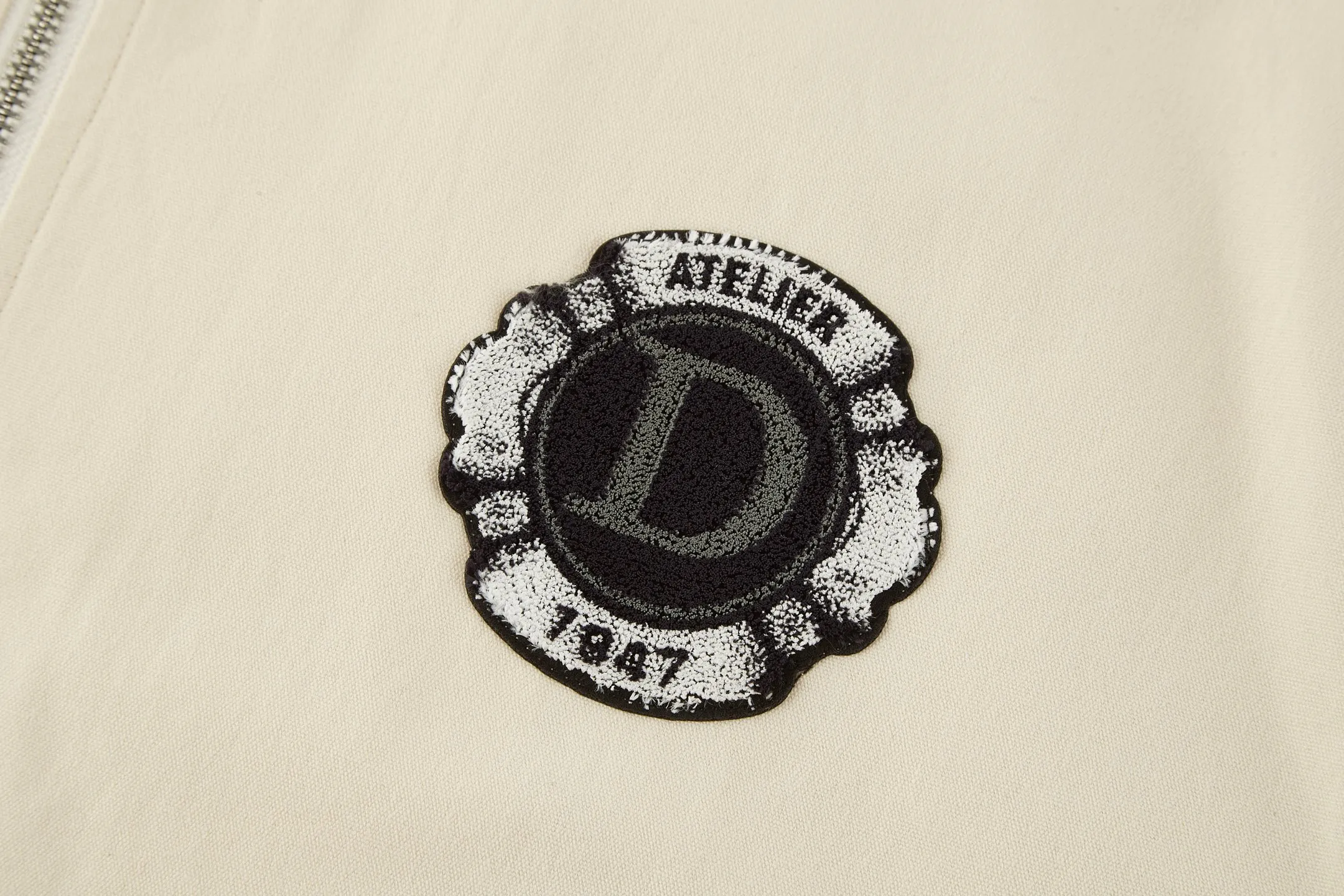 🅿️520 CD 1947 Badge Embroidered Baseball Jacket (off-white). The original version was purchased for 25,000 and developed. It is custom-woven cotton woven fabric with a slightly melting jacquard pattern. It is different from the texture of ordinary workwear on the market. The fabric feels very good. The main body of the back embroidery uses fixed-dye matte embroidery thread on the board and needle embroidery technology. Based on the overall size of the original image as the standard, the embroidery is accurately positioned with laser, and the edge is processed using a special overlocking method. The main lines of the pattern are outlined with needle embroidery and tatami embroidery can be used to fill in the background or details of the pattern. The pattern is embroidered with Tajima machine thousands of needles. The fine stitching method is dense and ultra-high density without revealing white. The pattern is clear and has a strong sense of lines and three-dimensionality. The added three-dimensional design enriches the spatial level of the overall picture. The hardware and accessories of the whole garment are all customized according to the original molding, with two-way zipper opening and closing, and a zipper puller engraved with the DR logo. Size:46-48-50-52