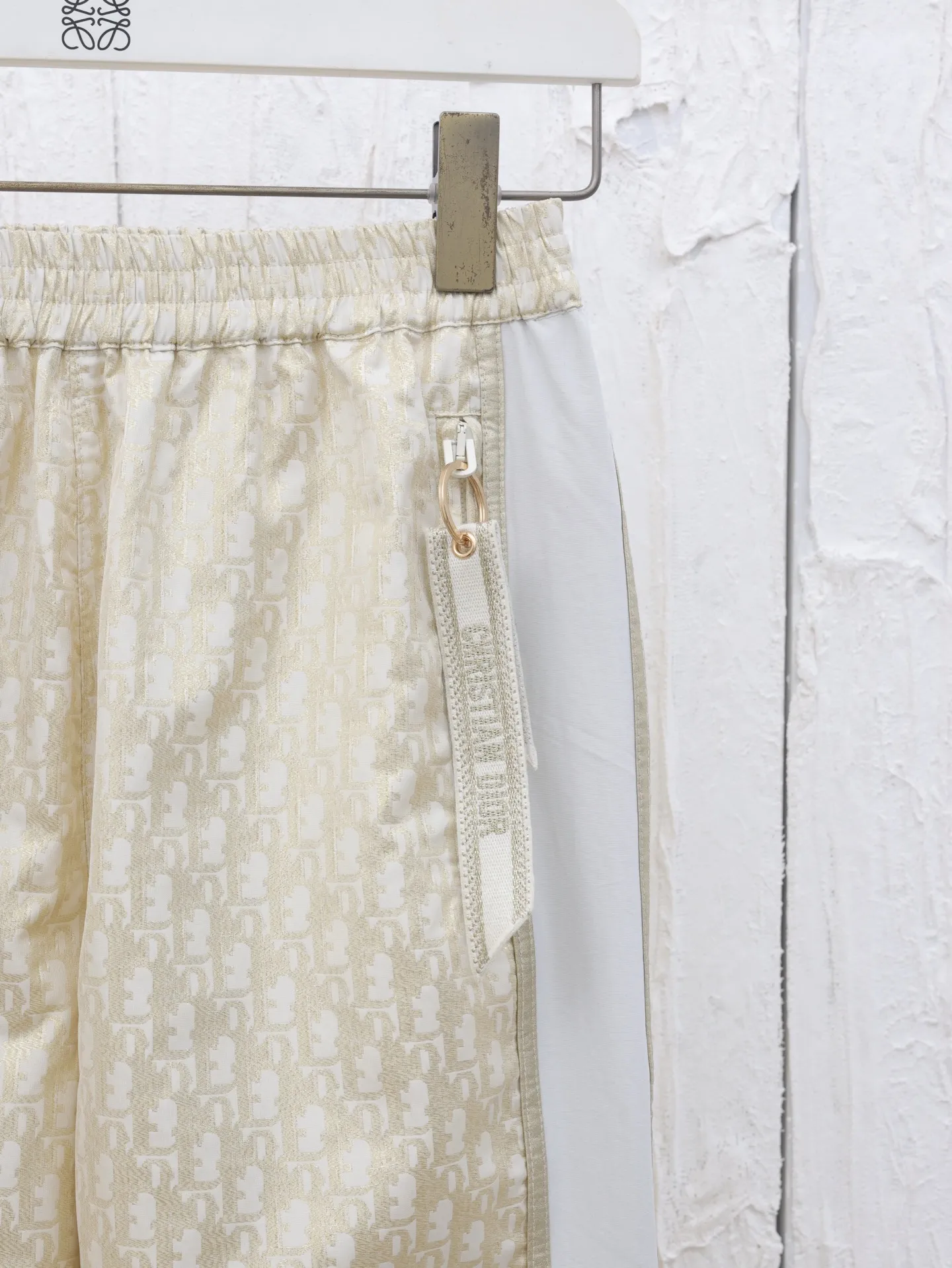 🅿️516 Dio*/Dior 25ss new trousers are decorated with classic Oblique print to pay tribute to the classic pattern launched by Dio in 1969. Crafted from white and gold-toned technical fabric, it has a loose fit and features Christian Dio's signature stripe pattern on the leg. Featuring side pockets and a rear zip pocket, it can be paired with other items featuring the Oblique print for a perfect look.  Size：S/M/L