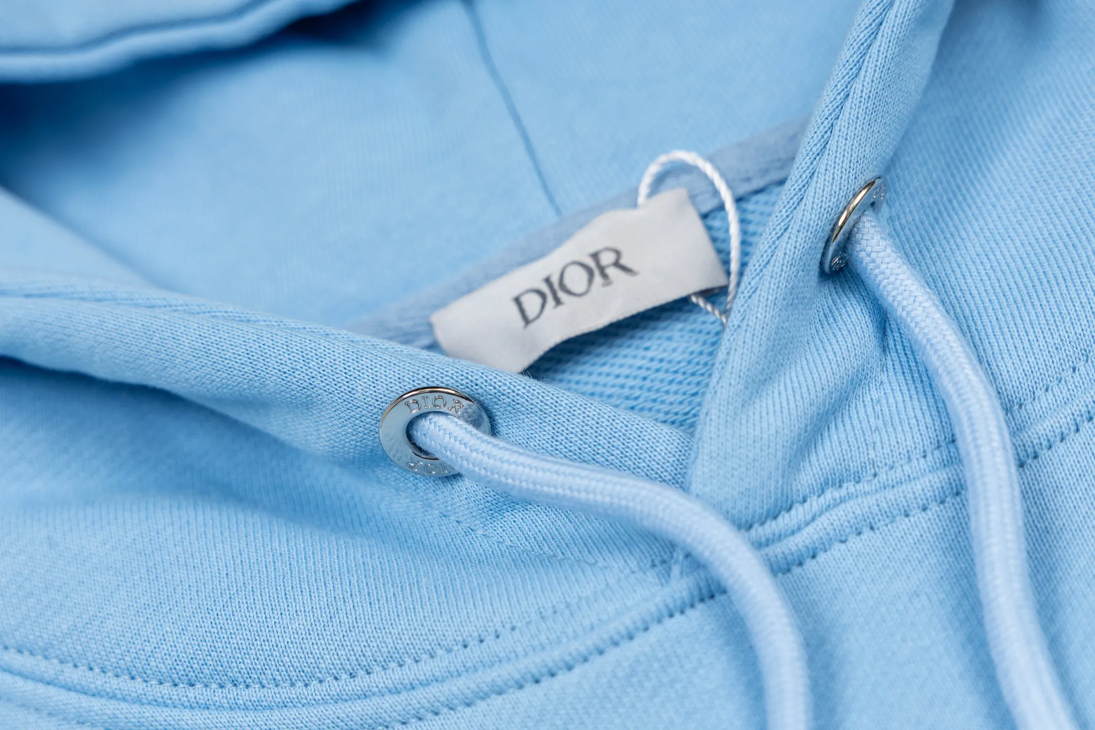 🅿️360 CD Logo Embroidered Hooded Sweatshirt (Blue) Original purchase and development for 3,599. The fabric is made of high-quality blue cotton fleece fabric, soft and comfortable to the touch. The delicate tonal CD Icon embroidery on the chest is low-key and elegant, highlighting the brand details. The drawstring hood design is paired with metal accessories engraved with the Dior logo to enhance the overall texture. The practical kangaroo pocket on the front is as beautiful as it is practical. Ribbed cuffs and hem ensure comfort while maintaining a structured silhouette. 100% cotton material brings excellent breathability and skin-friendly experience. The regular fit has a neat cut and is easy to match with a variety of bottoms. Exquisite embroidery technology and delicate fabric processing complement each other, reflecting Dior's consistent meticulous workmanship. This sweatshirt is the perfect blend of athleisure and haute couture, making it ideal for everyday style. Size:S-M-L-XL
