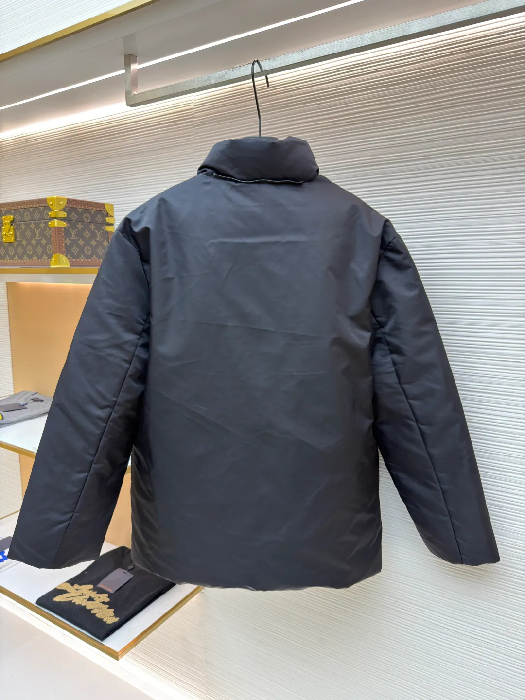 Prada mid-length nylon hooded down jacket ●Original version: purchased and developed for 15999 ●Item number: 1681587-D35 ●Fabric: white duck down fabric ●Technology: mechanical down filling ●Color: black ●Version: fitted version ●Weight: about 1155 grams ●Size: S-M-L-XL ●Description: Re-Nylon short down jacket uses environmentally friendly Re-Nylon material, the fabric density is very high It has strong tear resistance, strong stiffness and wear resistance. It is different from the Bird brand's hard shell, it is softer and has a very strong sense of functionality. Double-sided design: The biggest highlight of this down jacket is its double-sided design, which allows one piece of clothing to show two different styles and shapes, greatly increasing the diversity and fashion sense of wearing. Detachable hood: The down jacket is equipped with a detachable nylon hood, which users can easily remove or install according to weather changes or personal preferences, which is both practical and convenient. The details are exquisitely processed: the zipper design is simple and elegant, easy to operate; the closing design of the cuffs and hem effectively prevents the intrusion of cold wind, improving the warmth and comfort of wearing. All the hangtags, wash marks, air holes, snap buttons, and chest labels are all custom-made using original one-to-one molds.  The overall wiring is straight and delicate, the fabric is comfortable and soft, and the color is consistent without color difference. It can be matched with the same style to create a fashionable look and control various occasions. Customized accessories, complete with three standards, same style for men and women!