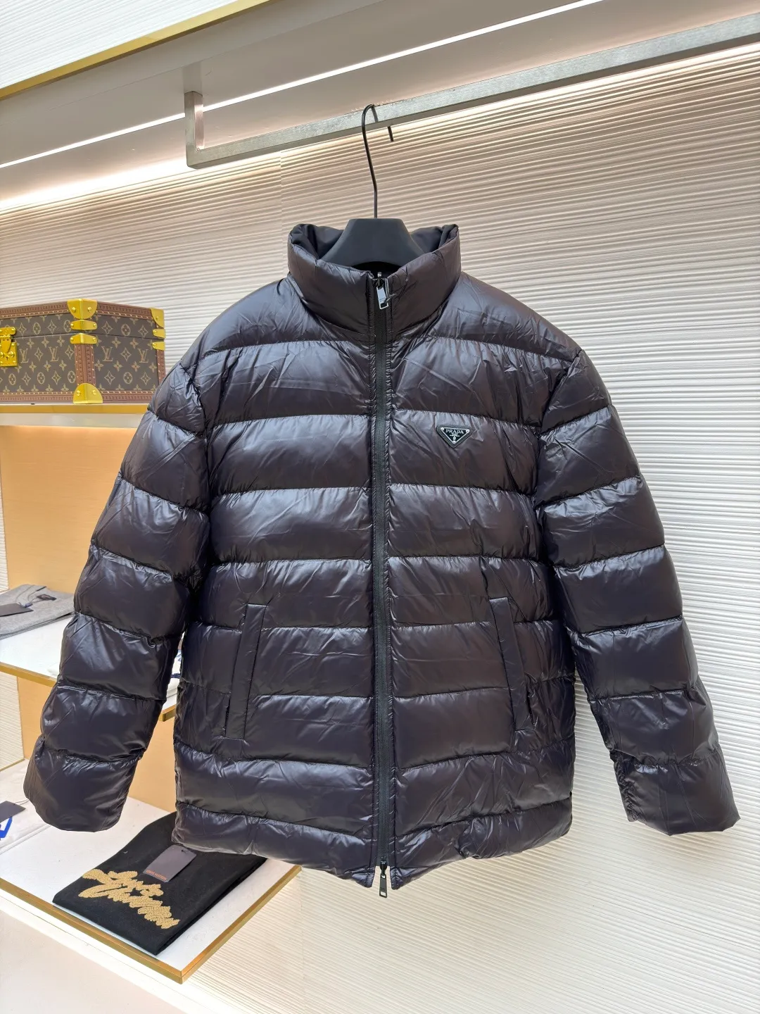 Prada mid-length nylon hooded down jacket ●Original version: purchased and developed for 15999 ●Item number: 1681587-D35 ●Fabric: white duck down fabric ●Technology: mechanical down filling ●Color: black ●Version: fitted version ●Weight: about 1155 grams ●Size: S-M-L-XL ●Description: Re-Nylon short down jacket uses environmentally friendly Re-Nylon material, the fabric density is very high It has strong tear resistance, strong stiffness and wear resistance. It is different from the Bird brand's hard shell, it is softer and has a very strong sense of functionality. Double-sided design: The biggest highlight of this down jacket is its double-sided design, which allows one piece of clothing to show two different styles and shapes, greatly increasing the diversity and fashion sense of wearing. Detachable hood: The down jacket is equipped with a detachable nylon hood, which users can easily remove or install according to weather changes or personal preferences, which is both practical and convenient. The details are exquisitely processed: the zipper design is simple and elegant, easy to operate; the closing design of the cuffs and hem effectively prevents the intrusion of cold wind, improving the warmth and comfort of wearing. All the hangtags, wash marks, air holes, snap buttons, and chest labels are all custom-made using original one-to-one molds.  The overall wiring is straight and delicate, the fabric is comfortable and soft, and the color is consistent without color difference. It can be matched with the same style to create a fashionable look and control various occasions. Customized accessories, complete with three standards, same style for men and women!