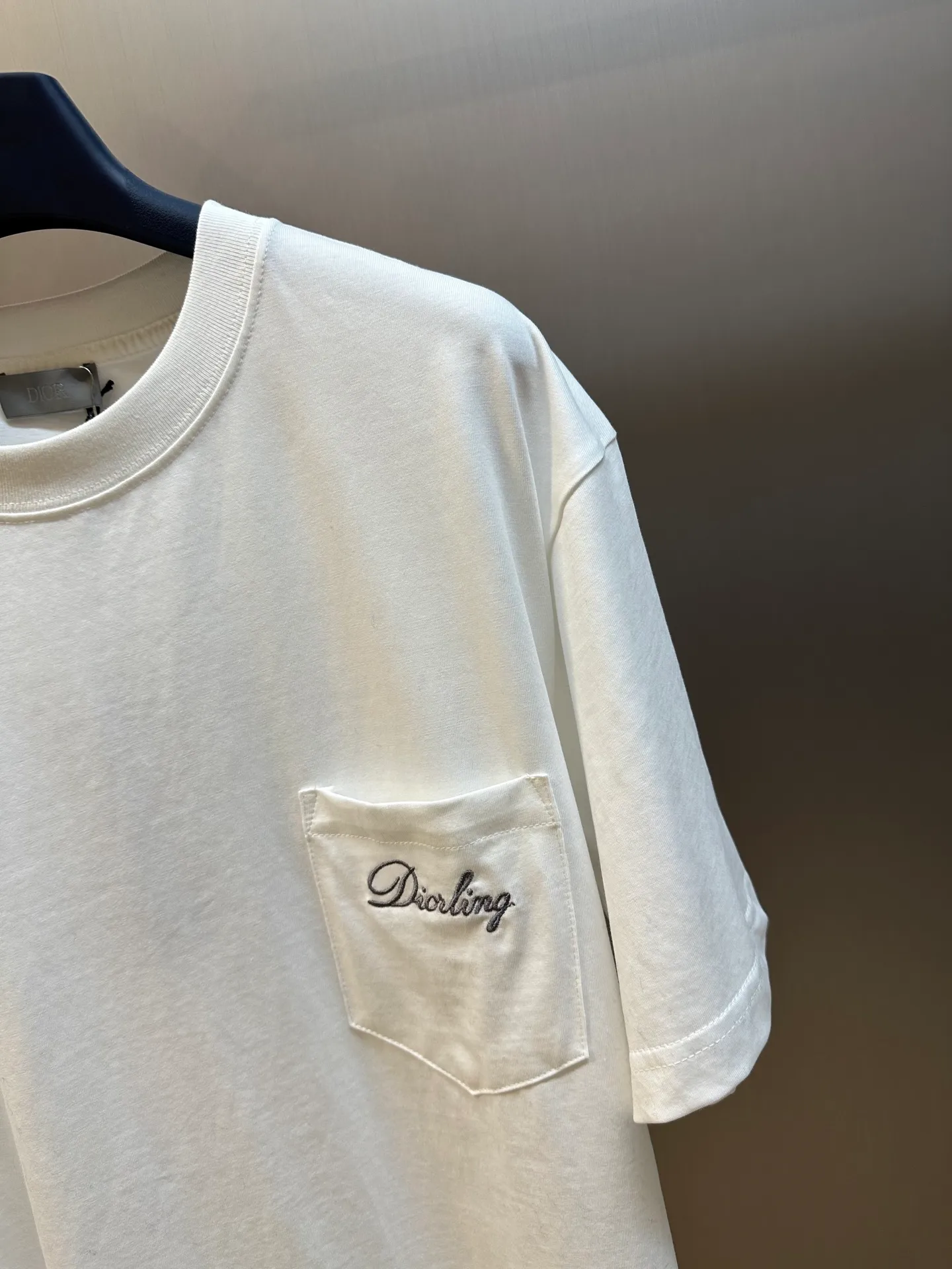 🅿️260 Dior Love Series Pocket Embroidery Round Neck Short Sleeve Cotton Jersey Fabric. Made of 24S special woven compact cotton fabric, 185g; with 32S double yarn thread, 300g. The strength of compact yarn is higher than that of traditional single yarn. The single fibers in compact yarn are closely arranged, which helps to improve the strength of the yarn. The ends of the fibers are all twisted into the yarn, so the yarn is very tight and the yarn has a smooth appearance with less hairiness. Compact spinning yarn has higher strength and less hairiness, making it less prone to fraying.  The chest is decorated with embroidery patterns, and the main body adopts precision stitch embroidery technology; the embroidery is very fine and dense, with clear patterns and strong lines and three-dimensionality. The linen material embroidery thread is combined with encrypted processing, and the embroidery body has a subtle matte visual texture; the embroidery effect is three-dimensional and full. The flat embroidery has a unique needle-to-needle design, and the embroidery is very fine and dense. The overall stitching is fine, with consistent fineness and texture, adding a sense of layering to the simple design.  Standard crew neck, short sleeve fit. The neckline is rounded and arc-shaped, suitable for various face shapes and body shapes; the sleeve length is moderate and ends just above the elbow, showing a smart and neat image. The slim fit can show off the wearer's body curves without sacrificing comfort. The collar, cuffs, hem and other parts are all sewn with fine double-needle stitching.  size：xs s m l