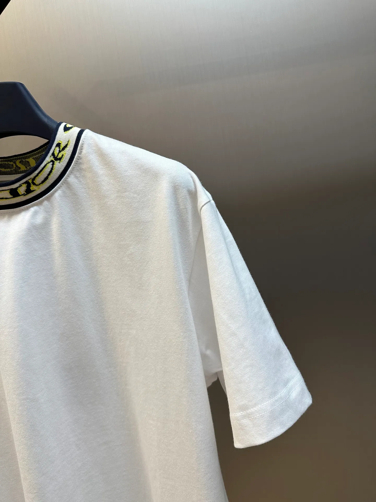 🅿️270 Dior artistic font rib short sleeves, cotton jersey fabric, made of 15S fine cotton plain weave, 230g; with threaded 32S double yarn rack, 300g. 15S is a relatively thick yarn used to make thicker and more durable fabrics. The fabric made of pure cotton natural fiber has the characteristics of good hygroscopicity, strong breathability, softness and comfort. Cotton fabrics are generally suitable for summer wear and can help keep your body dry and comfortable. The yarn passes alternately in the horizontal and vertical directions to form a simple cross structure; it has good elasticity and wear resistance.  The ribbed neckline is decorated with the joint series logo, the original artistic font is painted with flowers, and the flower collar pattern is woven with specific yarns of different colors. Fully computerized jacquard machine, the so-called computerized jacquard machine is to store the pattern data in a computer disk in advance, then put the disk into the computer of the loom, and the computer will control the weaving. The exquisite jacquard flat machine collar has clear and unique texture, rich color layers and is not easy to deform. Special double-layer weaving technology, rich color layering, strong three-dimensional jacquard effect on the surface, comfortable and skin-friendly, and good breathability.  The high-neck flat knit short-sleeved version and the round-neck short-sleeved T-shirt are restored in the design of the collar and cuffs, and special sewing methods or reinforcements are used to ensure the durability and comfort of these parts. Standard casual round neck short sleeves usually adopt a classic round neck design. The neckline is moderate in size, neither too tight nor too loose, and can well show the wearer's neck line.  size：xs s m l