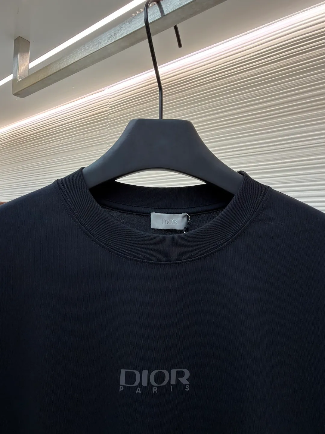 Dior Reflective Triangle Icon Round Neck Short Sleeve ●Original version: Purchased and developed by 6323 ●Item No.: 1681099-A00 ●Fabric: Jersey fabric ●Technology: Reflective lettering and embossed production ●Version: Fitted version ●Weight: about 220 grams ●Size: S-M-L-XL ●Description: The main body is made of 24S special woven compact cotton to make jersey fabric, weight 180g. High-count combed cotton yarn eliminates most of the short hairiness through compact spinning process, making the yarn smoother and stronger. The woven fabric structure is extremely dense, flat and soft, with excellent anti-pilling ability and durability, while retaining the natural advantages of pure cotton, which is breathable and skin-friendly. The neckline is made of 32S 1x1 rib with a weight of 300g. The finer yarn count creates a more delicate and tight thread, which provides better elasticity and deformation resistance than ordinary ribs, ensuring that the neckline can still remain stiff after being put on and taken off many times. The reflective engraving and embossing process is a sophisticated technology that combines safety functions with visual aesthetics. The core is to use a reflective lettering film with a built-in micro-glass bead layer. First, a high-precision laser cutting machine is used to engrave the outline according to the designed fonts and patterns to ensure that the edges are clear and burr-free. The cut reflective film is accurately attached to the surface of the fabric through heat transfer printing equipment under specific temperature and pressure, so that it is firmly combined with the fabric fibers. The case is matte silver-gray under normal conditions, but when illuminated by light, the micro-glass bead layer can achieve efficient retroreflection and instantly present a striking bright effect. The finished product is washable and abrasion resistant, perfectly meeting the dual needs of sportswear for functionality and visual tension. The overall wiring is straight and delicate, the fabric is comfortable and soft, and the color is consistent without color difference. It can be matched with the same style to create a fashionable look and control various occasions. Customized accessories, complete with three standards, same style for men and women!