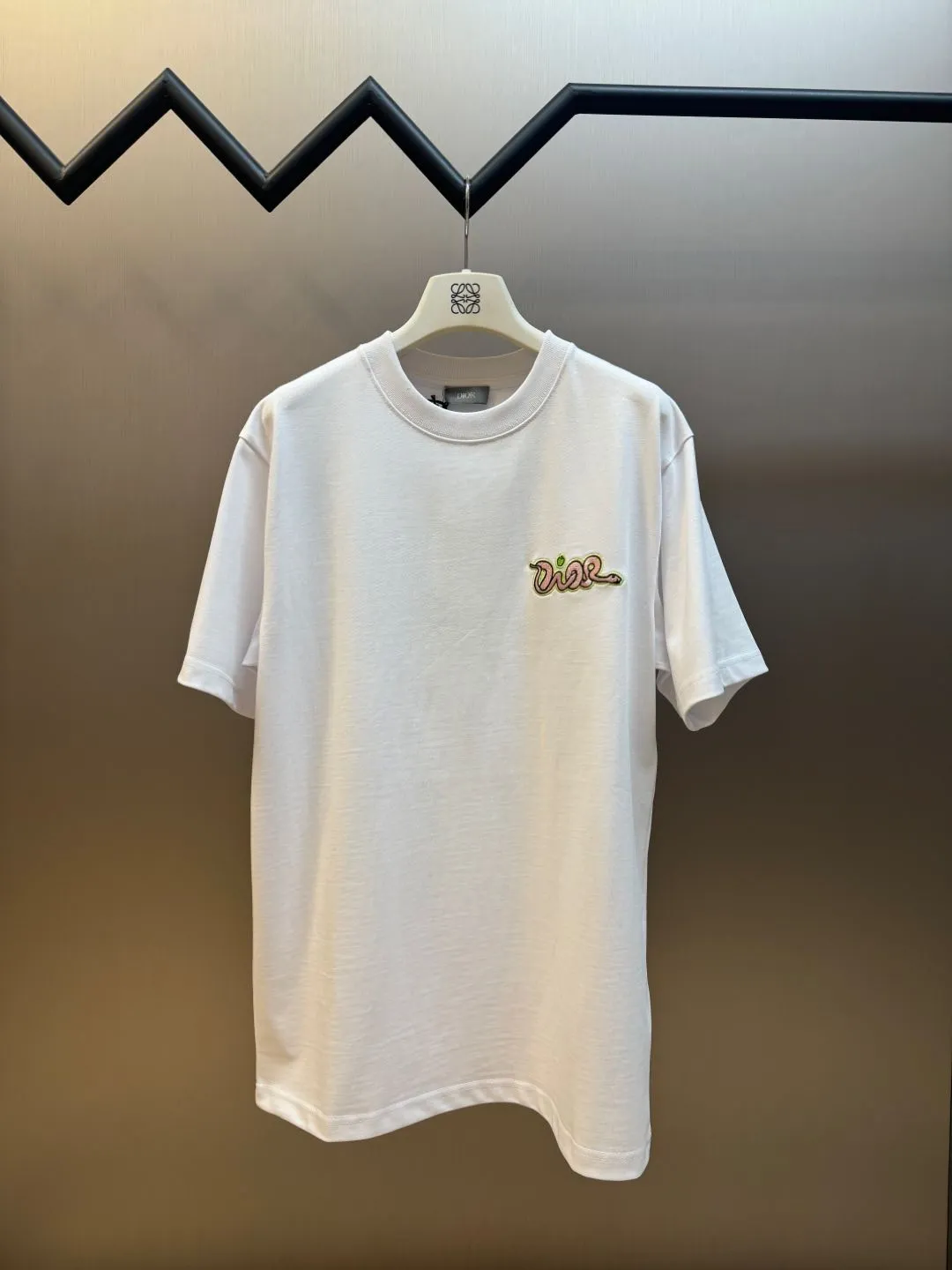 🅿️280 Dior Apple Snake Embroidered Chapter Short Sleeve Made of pure cotton 12S fine cotton plain fabric, 310g. The embroidery pattern is based on tatami embroidery technology. The embroidery uses a special single-needle arrangement. The stitches are tight and flat, forming a texture similar to the tatami grid, making the embroidery pattern have a strong three-dimensional and layered feel. Embroidered with silk threads of multiple colors, the colors are bright and contrasting, showing rich patterns and details.  The outline is stroked by needle embroidery, the embroidery pattern is matched with the brand logo design, and the brand letter logo is single-needle flat embroidered. Made from a variety of needlework; the outline of the pattern is embroidered with a single straight line and straight silk thread. The outline edges and letter embroidery are stitched together to create clear and rich three-dimensional layers.  The standard round neck and short-sleeved version has a rounded arc neckline, which is suitable for various face shapes and body shapes; the sleeve length is moderate and ends just above the elbow, showing a smart and neat image. The slim fit can show off the wearer's body curves without sacrificing comfort. The collar, cuffs, hem and other parts are all sewn with fine double-needle stitching.  size：xs s m l