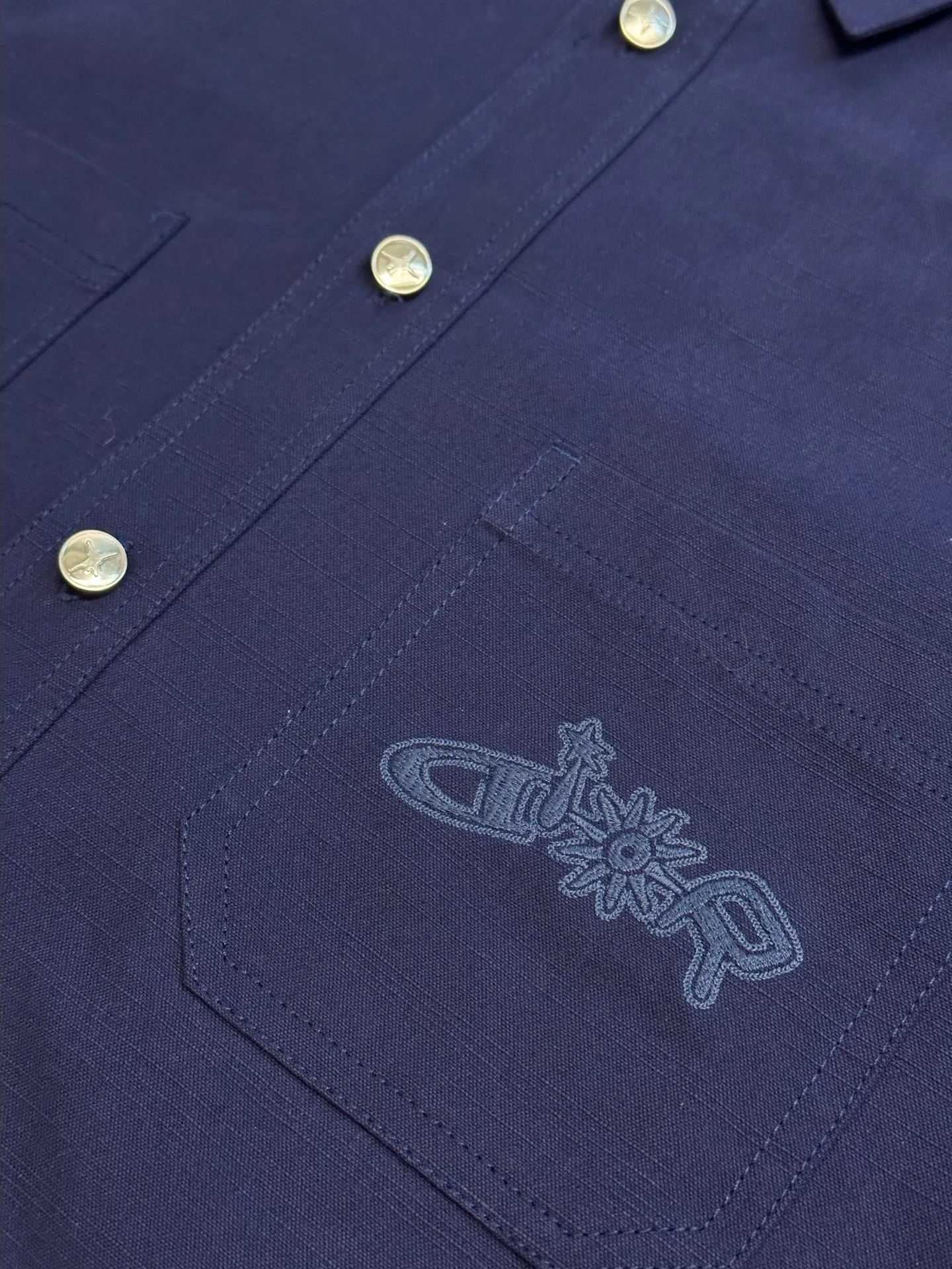 🅿️490 Dior LEWIS HAMILTON Curtain Call Shirt Crafted from blue cotton, it is decorated with patch pockets on the chest, one of which is embellished with tonal co-branded embroidery, reinterpreting the logo in a graphic style. Pair with shorts from the limited collection for a refined look.  Chambray is made of plain weave, which is characterized by interweaving yarn materials of different colors in the warp and weft. It can reflect different levels of light and shade under different light angles, and the colors are rich in changes. The cloth is light and thin in texture, smooth and soft in body, and comfortable to wear. After a specific finishing process, its elasticity and feel are further improved.  Flat stitch embroidery three-dimensional craft is a special embroidery technique that uses flat stitch to create embroidery with a three-dimensional feel. This process creates a richer three-dimensional effect and layering by precisely controlling the depth and angle of the stitches and increasing the density and length.  size:36.38.40.42