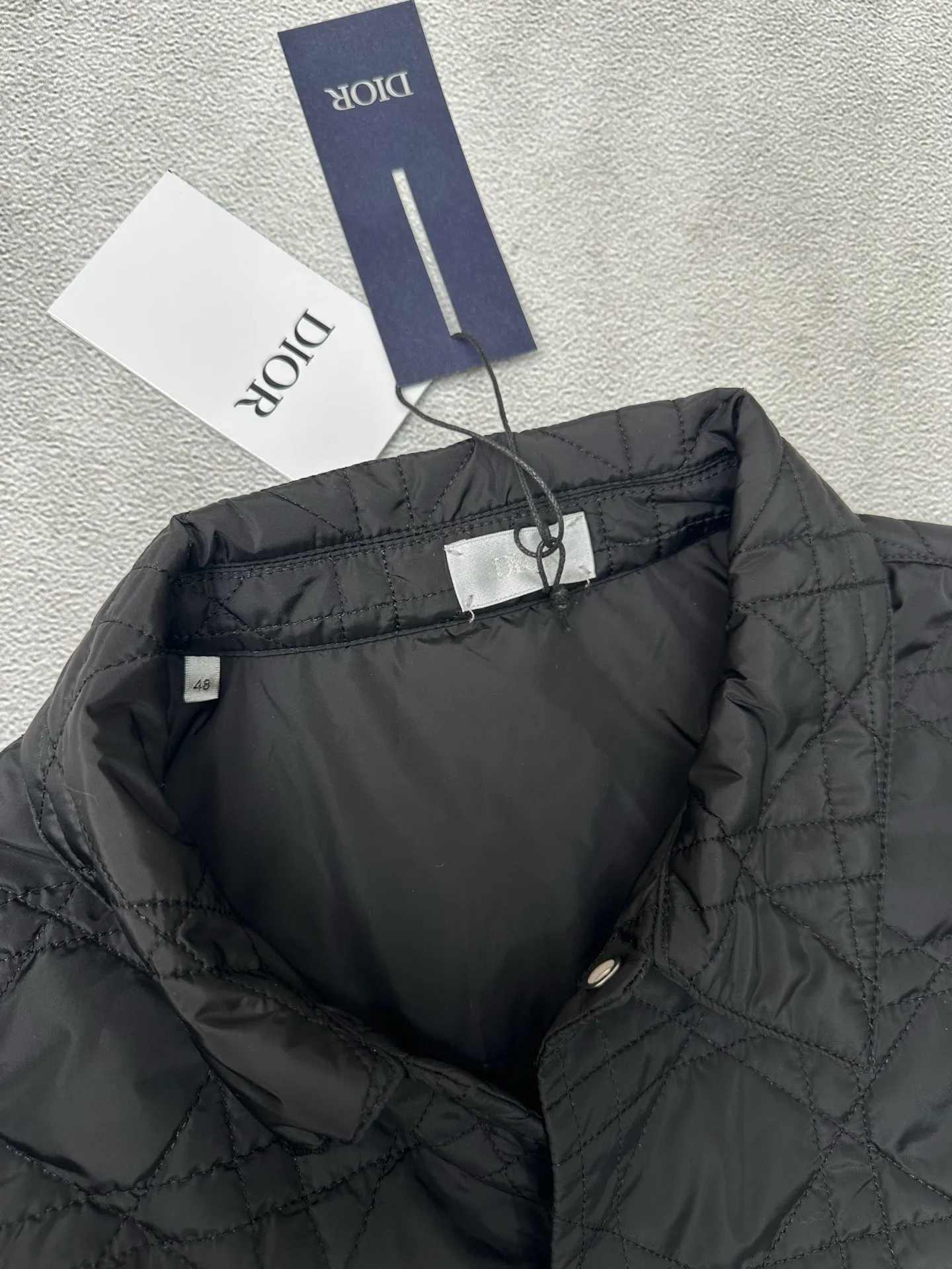 🅿️550 Dior 25ss new jacket shirt reinterprets the classic design and highlights modern style. Crafted from black technical fabric for a sleek silhouette, it's finished with a classic tonal quilted cannage pattern throughout. The chest patch pocket is decorated with +Christian+Dior+Couture+ embroidery, and the side slits are designed with snap buttons and can be worn open or buttoned. Blending traditional and modern styles, pair it with jeans or shorts for a sophisticated, stylish look.  Size: S M L XL