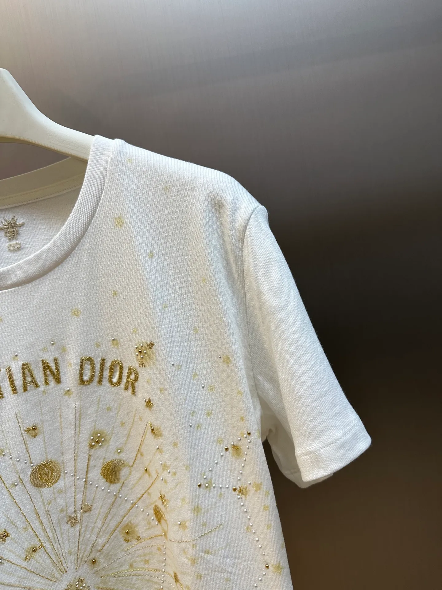 🅿️390 Women's Dior Gold Stars and Moon Heavy Embroidery Short Sleeves This T-shirt is carefully crafted from white cotton jersey fabric and decorated with gold-tone Dior Astral graphic print and embroidery, showing the Serpent and the phases of the moon, paying tribute to Mr. Dior's love for the constellations. The classic crew neck design and the Christian Dior Paris signature on the front add to the style. Pair with other Dior Astral pieces for a sophisticated and stylish look.  size：s m l
