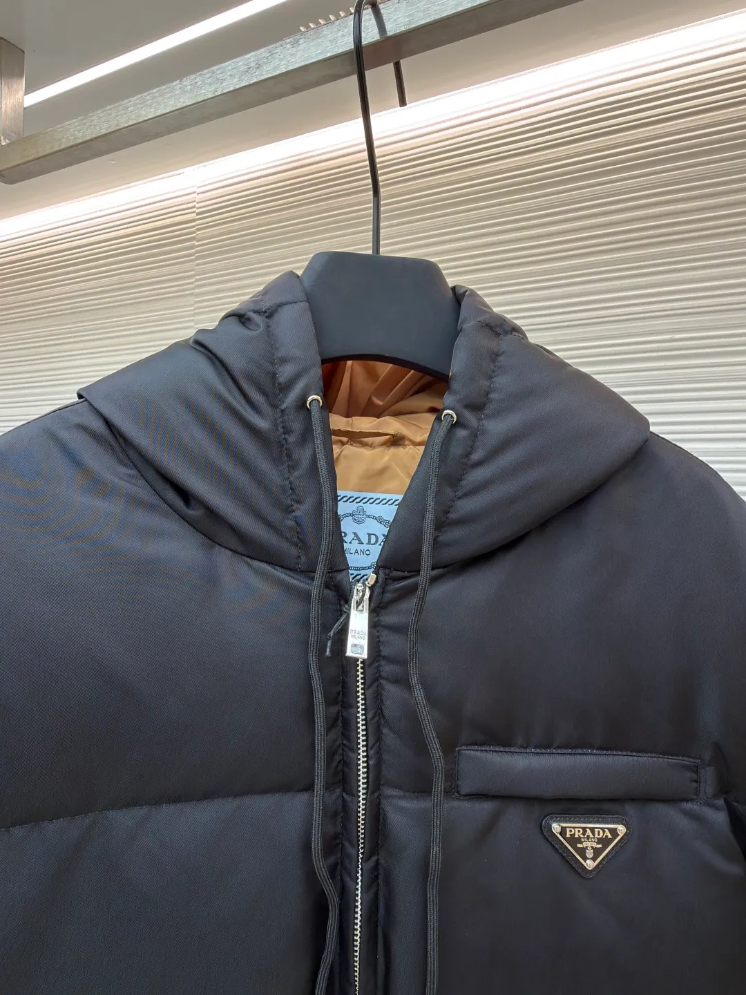 Prada Triangle Down Jacket ●Item No.: 1681316-C75 ●Fabric: White duck down fabric ●Technology: Mechanically filled with down ●Color: Black ●Version: Fitted version ●Weight: about 910 grams ●Size: S-M-L-XL ●Description: This down jacket is made of high-density water-repellent fabric, treated with a special coating, and has both windproof and anti-fouling properties. The hooded design is equipped with an adjustable drawstring, and the metal buckle at the end of the drawstring is customized by the brand, with fine texture and durability. The placket uses a two-way metal zipper with precise teeth, and the smoothness of the zipper has been tested for many rounds. The body of the garment is filled with high-quality goose down, which is evenly and plumply filled. The velvet is fixed through three-dimensional quilting technology to avoid velvet running while creating a layered silhouette. The brand triangle logo on the chest uses metal embossing + leather inlay technology, the edges are polished smooth, and the logo is three-dimensional and eye-catching. The pocket is a hidden zipper bag, and the zipper is the same color as the fabric, which is both practical and beautiful. The cuffs use micro-elastic edge processing to fit the wrist without restricting movement. The overall tailoring follows an oversize version, and seamless gluing technology is used at the splicing points to reduce thread exposure and improve wearing comfort and sophistication of garments. Every craftsmanship demonstrates Prada's strict standards for high-end clothing. The overall wiring is straight and delicate, the fabric is comfortable and soft, and the color is consistent without color difference. It can be matched with the same style to create a fashionable look and control various occasions. Customized accessories, complete with three standards, same style for men and women!