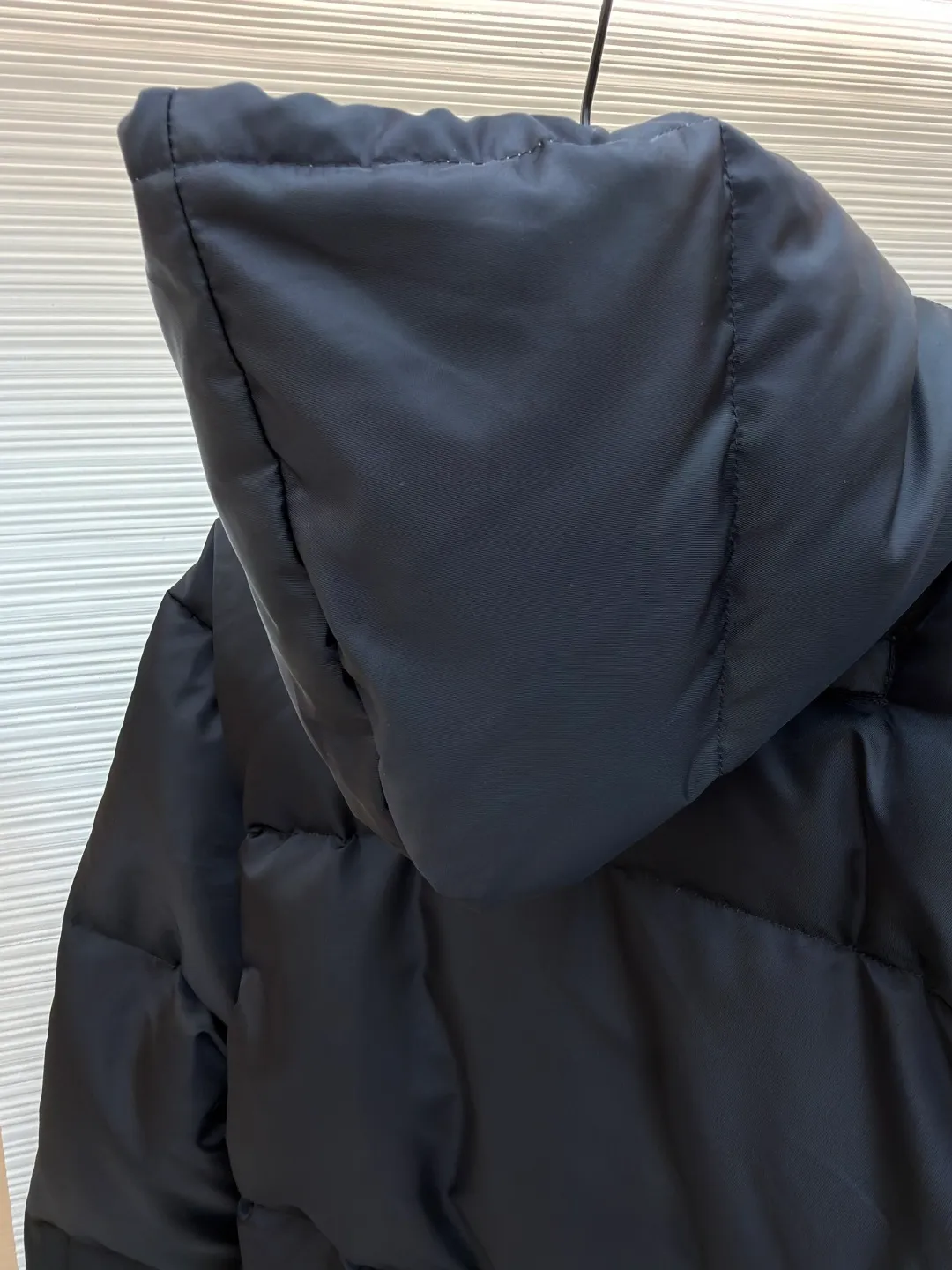 Prada Triangle Down Jacket ●Item No.: 1681316-C75 ●Fabric: White duck down fabric ●Technology: Mechanically filled with down ●Color: Black ●Version: Fitted version ●Weight: about 910 grams ●Size: S-M-L-XL ●Description: This down jacket is made of high-density water-repellent fabric, treated with a special coating, and has both windproof and anti-fouling properties. The hooded design is equipped with an adjustable drawstring, and the metal buckle at the end of the drawstring is customized by the brand, with fine texture and durability. The placket uses a two-way metal zipper with precise teeth, and the smoothness of the zipper has been tested for many rounds. The body of the garment is filled with high-quality goose down, which is evenly and plumply filled. The velvet is fixed through three-dimensional quilting technology to avoid velvet running while creating a layered silhouette. The brand triangle logo on the chest uses metal embossing + leather inlay technology, the edges are polished smooth, and the logo is three-dimensional and eye-catching. The pocket is a hidden zipper bag, and the zipper is the same color as the fabric, which is both practical and beautiful. The cuffs use micro-elastic edge processing to fit the wrist without restricting movement. The overall tailoring follows an oversize version, and seamless gluing technology is used at the splicing points to reduce thread exposure and improve wearing comfort and sophistication of garments. Every craftsmanship demonstrates Prada's strict standards for high-end clothing. The overall wiring is straight and delicate, the fabric is comfortable and soft, and the color is consistent without color difference. It can be matched with the same style to create a fashionable look and control various occasions. Customized accessories, complete with three standards, same style for men and women!