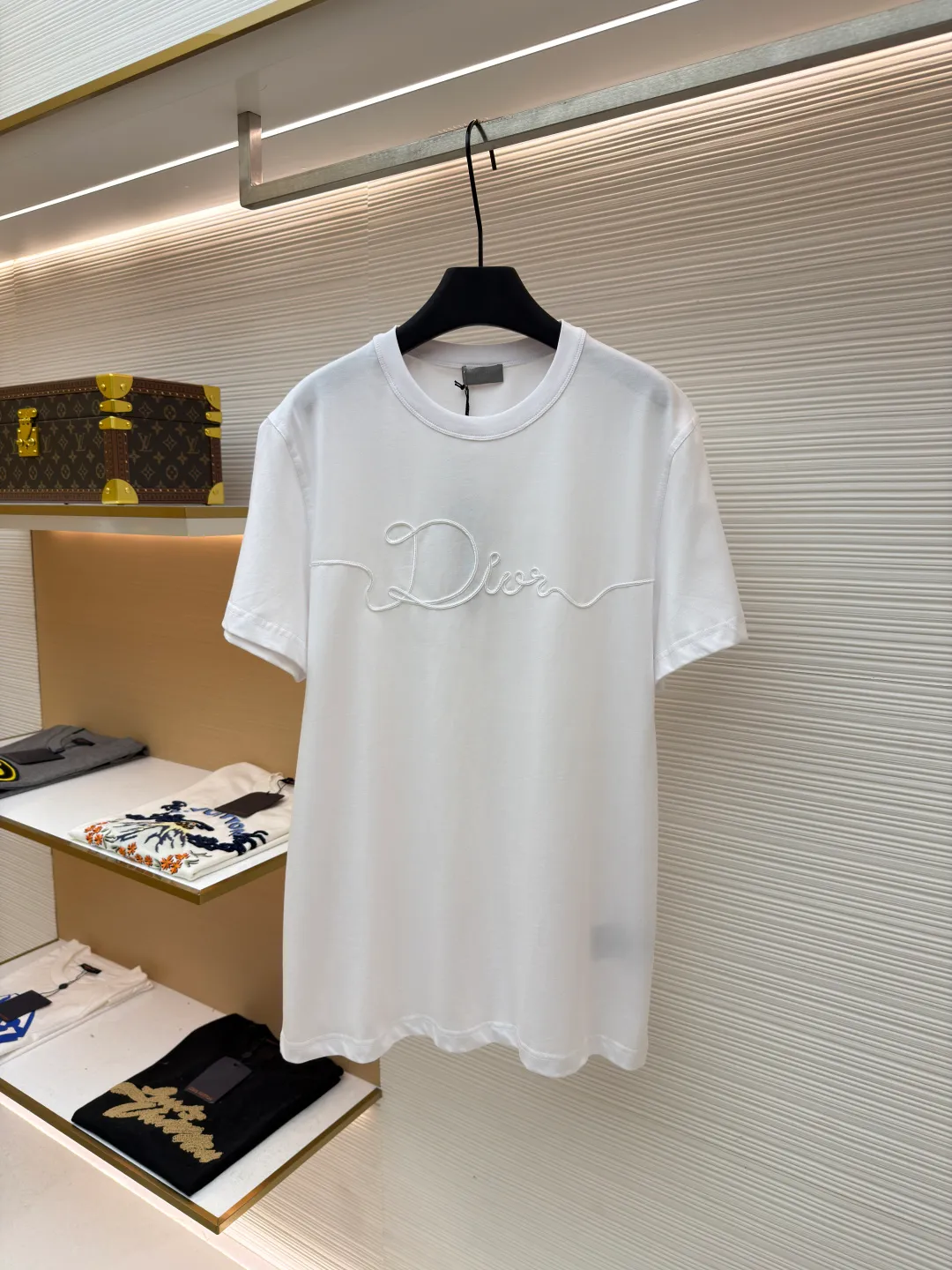 Dior satin emblem round neck short sleeves ●Original version: purchased and developed by 7089 ●Item number: 1681695-A00 ●Fabric: cotton jersey fabric ●Technology: embroidery production ●Color: white ●Version: fitted version ●Weight: about 205 grams ●Size: XS-S-M-L ●Description: The main body is made of 24-count special-spun compact cotton. The weight of 185g/㎡ is light to medium, ensuring the lightness, breathability and good drape of the T-shirt. It is suitable for both spring wear alone and as an inner layer. With 32 pieces of 1×1 rib, 300g/㎡. Its special spinning and compacting process means that compact spinning technology is used in the spinning process, which effectively reduces the hairiness of the yarn, making the yarn smoother and stronger. The woven fabric therefore has the advantages of compact structure, smooth surface, and resistance to pilling. The final dark gray tone is combined with the simple texture of jersey to create a high-end matte texture. Embroidery decoration in the form of satin ribbons, which are fixed on the fabric through special processing. The texture brought by this process is usually different from the woven texture and slight luster of the main knitted fabric. It forms a delicate and accessible visual and tactile focus on the matte dark gray base, enhancing the craftsmanship, design and uniqueness of the single product. The overall wiring is straight and delicate, the fabric is comfortable and soft, and the color is consistent without color difference. It can be matched with the same style to create a fashionable look and control various occasions. Customized accessories, complete with three standards, same style for men and women!