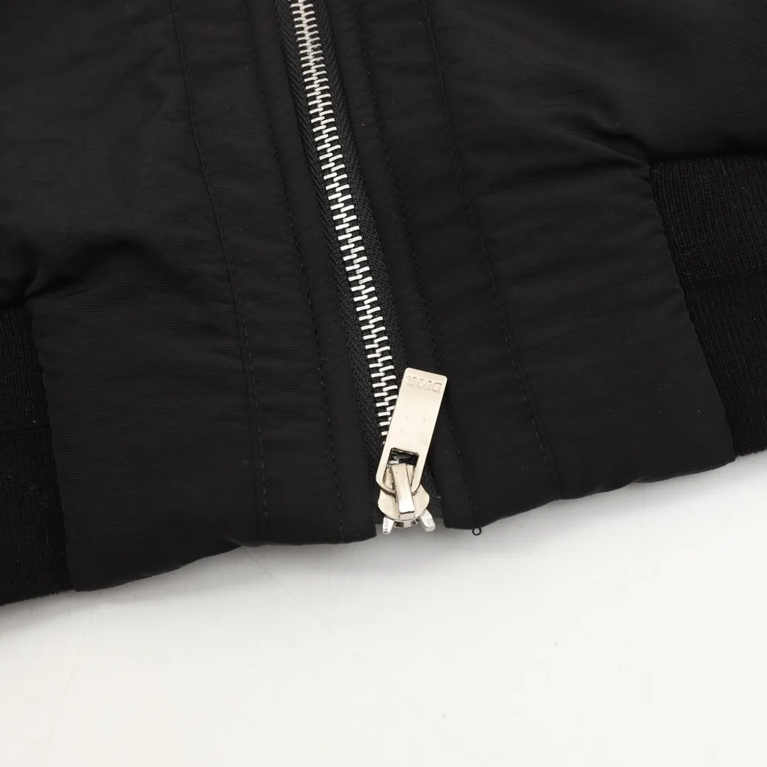 🅿️570 DIOR/Dior Teddy Velvet Logo Zipper Jacket The polyester filament is passed through a circular knitting machine, and the warp and weft are woven into each other into a double-sided knitted structure, with flat loops on the front and back. The polar fleece fabric is formed after a series of processes such as dyeing, raising, carding, shearing, and polarization. The suede texture is soft and the fiber characteristics make it almost non-absorbent. It can quickly drain sweat to the outer layer of the fabric and evaporate quickly, maintaining good breathability. The suede surface can lock the air and form a stagnant air layer around the body, effectively preventing heat loss and providing good warmth retention properties. Using quilted cannage pattern, the seamstress precisely adjusts the speed of the machine and stitch density, so that the stitches are smooth and even during the operation. After completion, regular diagonal quilting lines will be formed, which will inadvertently enhance the overall texture when putting it on and taking it off. Tightly fasten the fabric and cushioning material to the frame of the embroidery machine. The embroidery machine uses sparse stitches along the pattern of the cushion layer to outline the filling area of ​​the pattern. Then it runs the pattern of the overlay layer, using dense stitches to perfectly cover the foam cushion layer. After finishing, the edges of the patch will have no burrs and the pattern will be clear. Size：XS-L