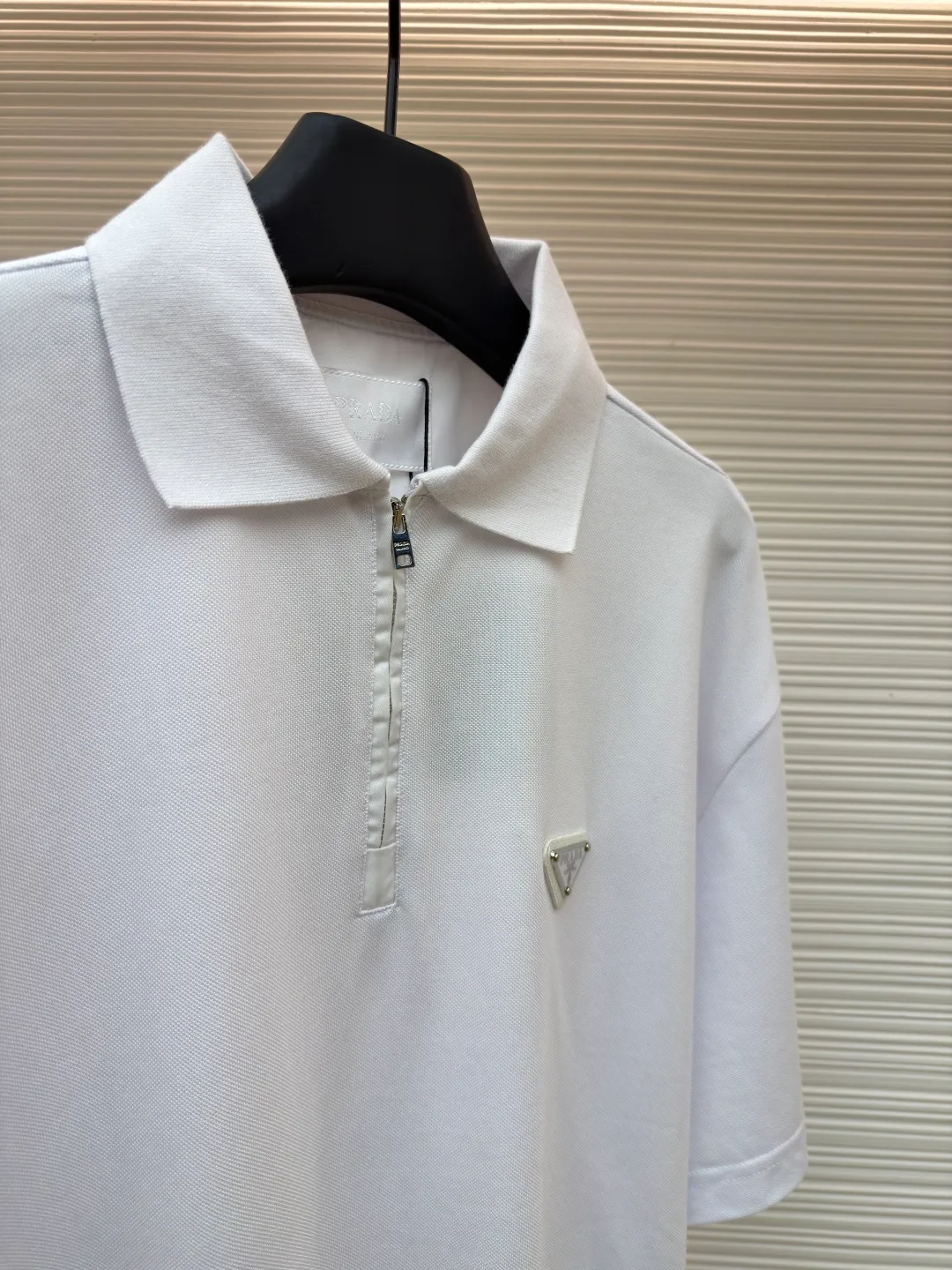 Prada triangle logo Polo shirt ●Original version: Purchased and developed for 7600 ●Item number: 1682423-A10 ●Fabric: pique cotton fabric ●Technology: Fabric washing and production ●Color: white ●Version: Fitted version ●Weight: about 310 grams ●Size: S-M-L-XL ●Description: Customized Jing embroidered Qiluo cotton pique silk, delicate and smooth, tight and elastic texture The iconic enamel-coated triangular metal logo is embellished to highlight the elegance and nobility of the brand. It is integrated with zipper fashion elements. Casual yet stylish, elegant yet fashionable, a fashionable and versatile item. It shines with a unique light. The "Prada triangle mark" is positioned more accurately using imported special infrared machines. It is strong and strong, and the fabrics have been washed. It has a better hand feel and texture. It is not easy to deform, not easy to shrink, not easy to fade, and maintains long-term beauty. The overall wiring is straight and delicate, the fabric is comfortable and soft, and the color is consistent without color difference. It can be matched with the same style to create a fashionable look and control various occasions. Customized accessories, complete with three standards, same style for men and women!