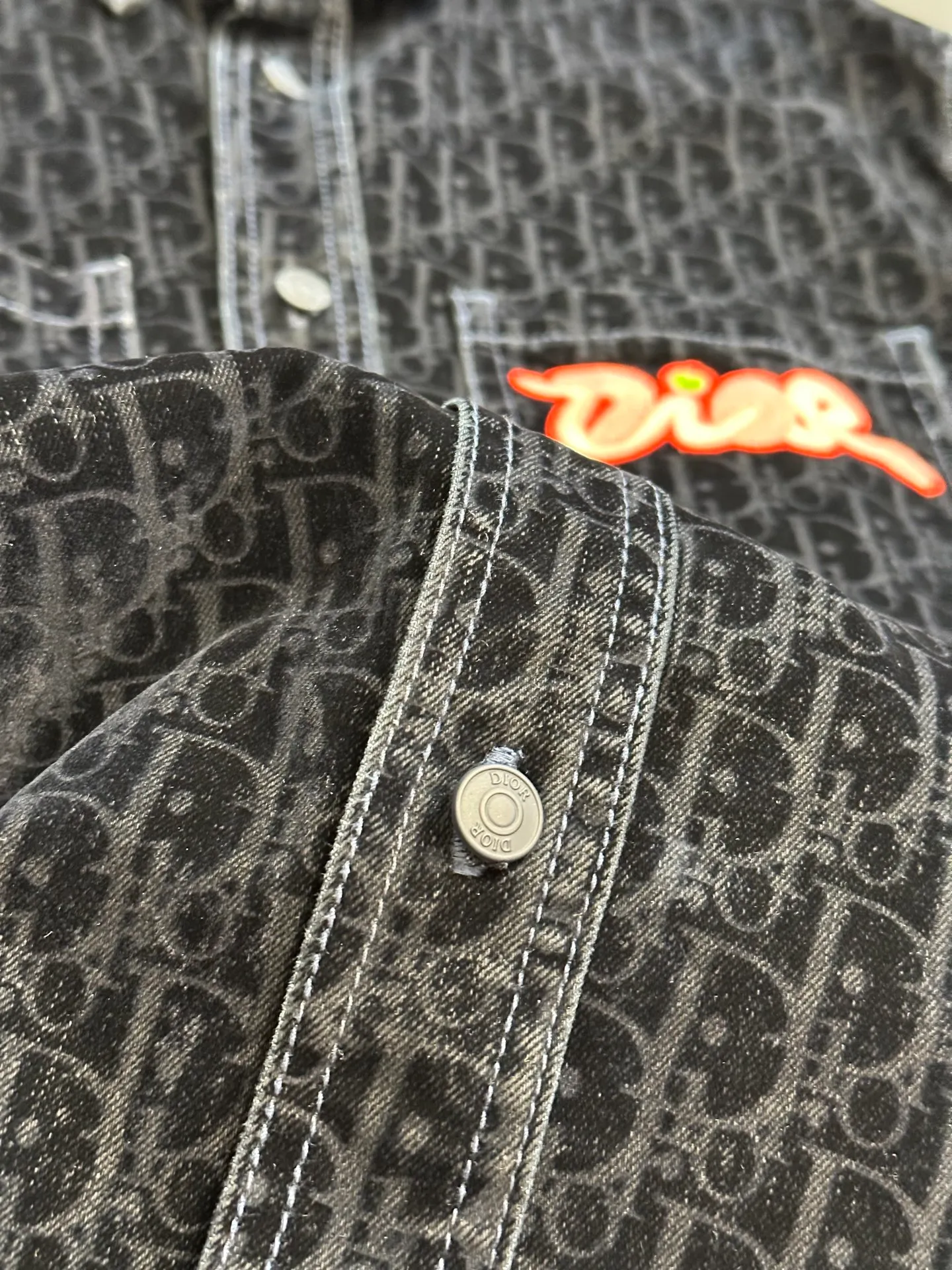 🅿️680 Dior x KAWS joint denim jacket This jacket and shirt is from the DIOR AND KAWS limited series. Crafted from blue cotton-blend denim, it features the classic Oblique print throughout and a green DIOR AND KAWS embroidered patch that reinterprets the Dior logo in a colorful snake shape. Featuring two chest patch pockets, it can be paired with jeans or shorts for a casual yet stylish look.  size:37.38.40.42.44