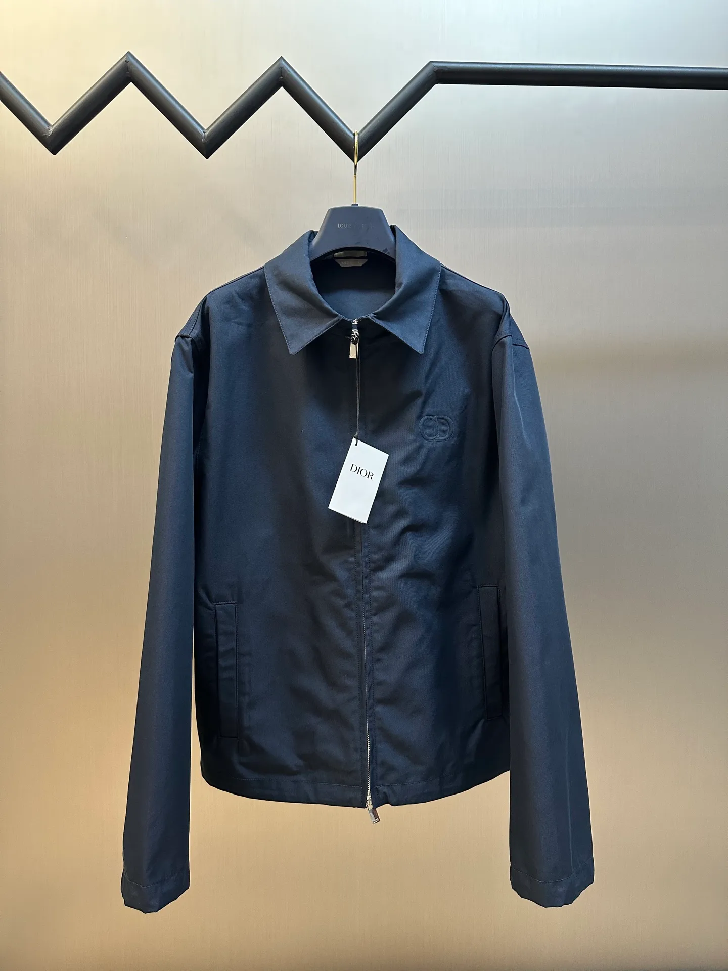 🅿️650 DIOR Embroidered Lapel Jacket Made of 100% cotton and polyester fiber with cotton twill body and lining. The shuttle loom shuttles between the warp and weft yarns to form the diagonal grain of the twill fabric. The cotton material has good breathability, is skin-friendly and comfortable, and the twill weave makes the fabric have a tight structure, high-grade texture, and is easy to take care of on a daily basis.  Through careful tailoring, the D family's classic casual and fashionable style is formed, and the lapel design does not lose sight of the wearing requirements for formal occasions. The two-way zipper closure increases its practicality and wearing style. It is paired with a zipper puller engraved with the brand logo. The CD icon embossed embroidery on the chest highlights the brand's unique style and recognition.  The shoulder position uses double-needle technology to connect the sleeves to the shoulders, making it firm and linear. There are side pockets on the left and right sides, and the piping process is used to wrap the fabric around the edges of the pockets, making it stronger and more aesthetically pleasing. The drawstring design at the hem allows you to adjust the tightness according to personal preference and is fixed with an elastic buckle.  size：s m l xl