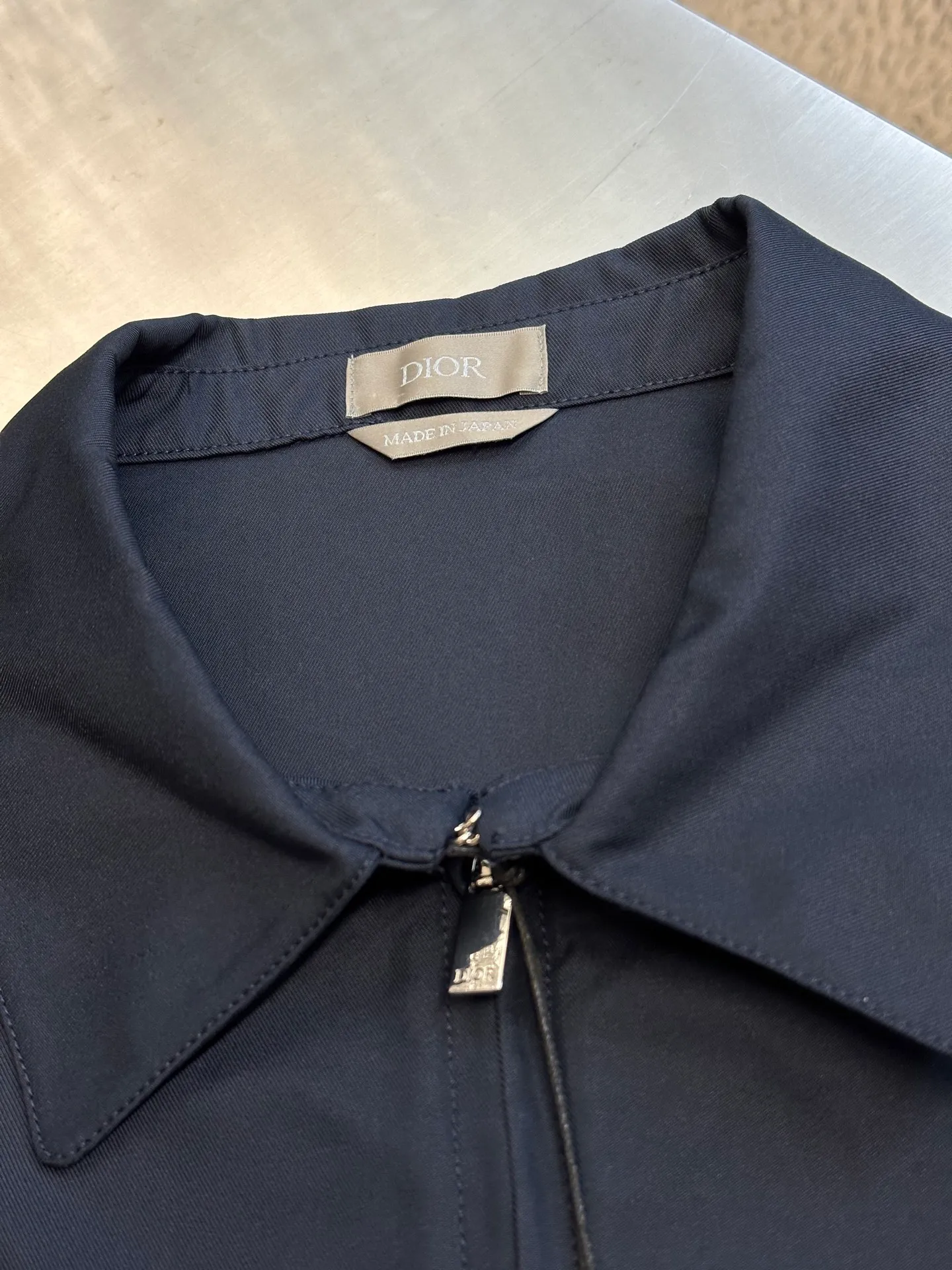 🅿️650 DIOR Embroidered Lapel Jacket Made of 100% cotton and polyester fiber with cotton twill body and lining. The shuttle loom shuttles between the warp and weft yarns to form the diagonal grain of the twill fabric. The cotton material has good breathability, is skin-friendly and comfortable, and the twill weave makes the fabric have a tight structure, high-grade texture, and is easy to take care of on a daily basis.  Through careful tailoring, the D family's classic casual and fashionable style is formed, and the lapel design does not lose sight of the wearing requirements for formal occasions. The two-way zipper closure increases its practicality and wearing style. It is paired with a zipper puller engraved with the brand logo. The CD icon embossed embroidery on the chest highlights the brand's unique style and recognition.  The shoulder position uses double-needle technology to connect the sleeves to the shoulders, making it firm and linear. There are side pockets on the left and right sides, and the piping process is used to wrap the fabric around the edges of the pockets, making it stronger and more aesthetically pleasing. The drawstring design at the hem allows you to adjust the tightness according to personal preference and is fixed with an elastic buckle.  size：s m l xl