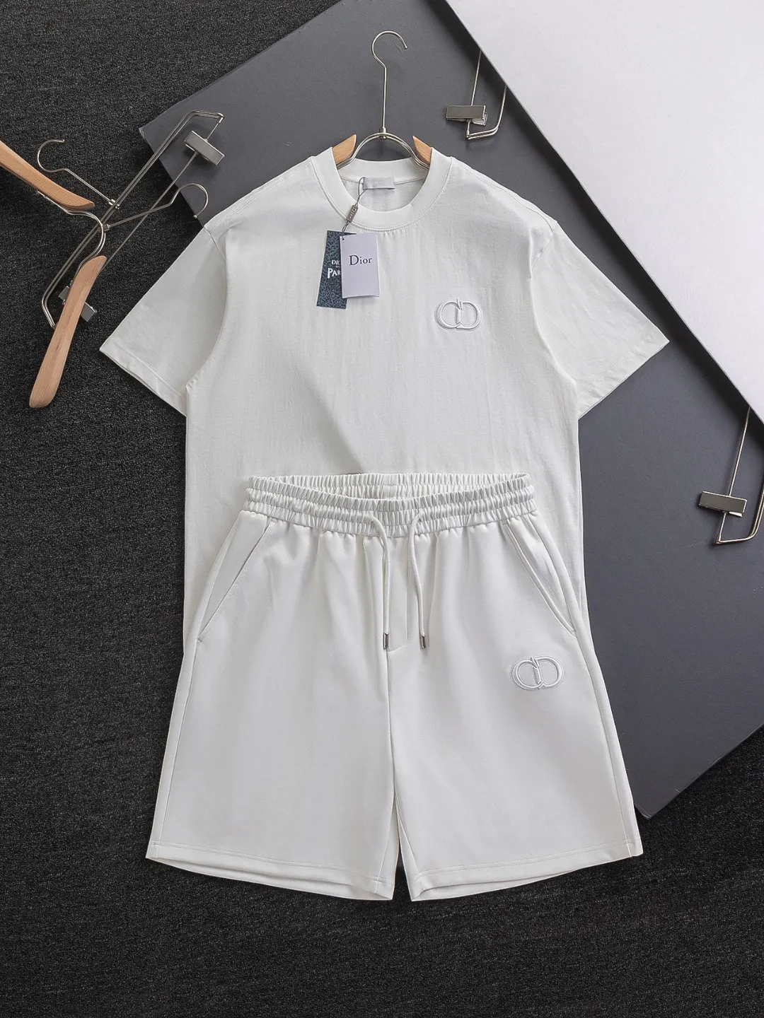 🅿️370 Dior CD micro-wide version S-XL (suit) CD 25SS New product official website for sale at the same time Simple CD letter short-sleeved shorts on the front 🪡 Embroidered logo pattern Back pocket As the leader in the luxury world, the D family is well-deserved. The first thing that catches the eye is the loose and comfortable three-color solid color black, white and blue. The ribbed short-sleeved shorts have become the best modification of the style, and the D family has the upper and lower body LOGOs listed on the chest. It also has a unique letter logo patch embroidery design, which highlights the texture! The most traditional modification method combined with the simplest color scale contrast forms the strongest and direct contrast, and this is often the most concise and clear minimalist modification method~~A nostalgic classic atmosphere also spreads in this work inadvertently! ! Featuring a distinctive 47 logo patch embroidery on the front, a unique tribute to Dior's historic year! Coupled with the blessing of cotton material, both the upper body comfort and the existence are unparalleled. It can be said to be a must-have companion in summer. The excellent breathability and comfortable wearing feeling are unparalleled~ Recommended! ! Color: Black White White + Blue Black + Blue Size Chart: S: Shoulder Width 45.5-Bust 52-Length 70 M: Shoulder Width 47-Bust 54-Length 72 L: Shoulder Width 48.5-Bust 56-Length 74 XL: Shoulder Width 50-Bust 58-Length 76 Pants Size: S-XL Size Chart: S: Sitting circumference 58 - Waist circumference 54 - Trouser length 43.5 M: Sitting circumference 60 - Waist circumference 56.5 - Trouser length 45 L: Sitting circumference 62 - Waist circumference 59 - Trouser length 46.5 XL: Sitting circumference 64 - Waist circumference 61.5 - Trouser length 48