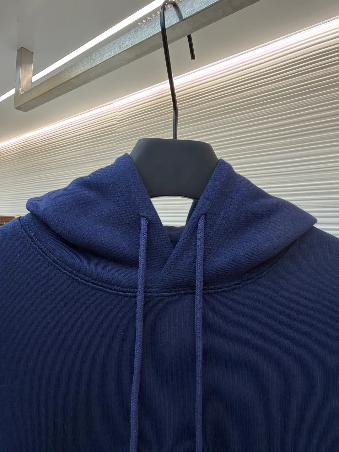 Dior classic logo embroidered hooded sweatshirt ●Item number: 1682333-A75 ●Material: cotton fabric ●Technology: embroidery production ●Color: navy blue ●Version: fitted version ●Weight: about 730 grams ●Size: XS-S-M-L ●Description: It adopts a fleece fabric structure of 26 counts of double yarn + 10S plush bottom, with a weight of 380g/㎡, and 21 counts of 1x1 ribs with a weight of 470g/㎡. It is used for the cuffs and hem. Its extremely high weight ensures the ultimate thickness, stiffness and deformation resistance of these closing parts, forming a unified and strong outline with the body. The fabric is a heavyweight and high-quality sweatshirt fabric. The 26-count double yarn forms a smooth, delicate and strong outer surface of the fabric, ensuring good color fastness and appearance. The 10S plush base undergoes a precise fleece or brushing process to form a layer of rich, dense and uniform fluff on the inside of the fabric. This makes the sweatshirt have a crisp and skeletal feel on the outside and an extremely soft and warm feel on the inside. White tone twill needle embroidery process. Needle embroidery is a straight line embroidery with stitches closely connected and evenly arranged. It is often used to outline clear and sharp outlines. This stitch is used to embroider a diagonal stripe pattern with a certain angle and width. Use white embroidery thread to follow the preset diagonal trajectory and perform precise embroidery with high-density stitches. On the high-weight fabric base, simple, exquisite and three-dimensional line decoration is created. The contrast between white and fabric color is sharp, and the slightly convex texture brought by the embroidery adds a visual and tactile layer, effectively enhancing the exquisite style of the basic sweatshirt. The overall wiring is straight and delicate, the fabric is comfortable and soft, and the color is consistent without color difference. It can be matched with the same style to create a fashionable look and control various occasions. Customized accessories, complete with three standards, same style for men and women!