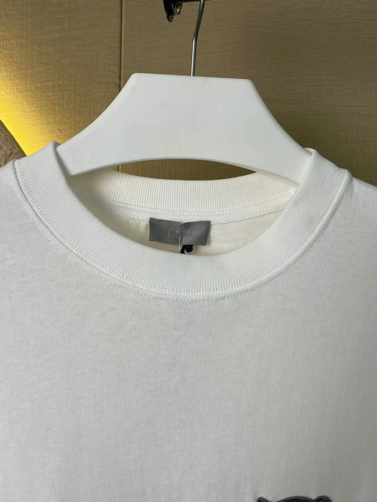 🅿️170 Dior Patch Letter Short Sleeve Color: navy blue (new custom dyed color), apricot, white, size S-XL, made of pure cotton 12S fine cotton plain weave, weight 260g. The front is decorated with contrasting logo patches and small embroidered stamps, forming a decorative and iconic embroidery product. The logo is made of imported custom-made embroidery thread, which is dyed with lustrous mercerized embroidery thread, giving it a uniform and glossy finish. The exquisite embroidery machine combines complex embroidery needlework and fine detail processing to create a three-dimensional micro-relief embroidery effect; at the same time, it is highly durable and wear-resistant. The standard round neck short-sleeved version, with a rounded arc neckline, is suitable for various face shapes and body shapes; the moderate sleeve length ends just above the elbow, showing a smart and neat image. The slim fit can show off the wearer's body curves without sacrificing comfort. The collar, cuffs, hem and other parts are all sewn with fine double-needle stitching.  size：xs s m l