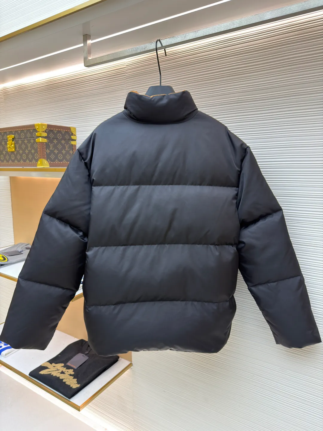 Prada logo stand collar down jacket ●Item number: 1681794-C75 ●Material: white duck down fabric ●Technology: mechanical down filling ●Color: black ●Version: fitted version ●Weight: about 855 grams ●Size: S-M-L-XL ●Description: The recycled nylon fabric made of 100% nylon is woven into a tight and tough fabric through advanced textile technology. The strength of the frame is increased to effectively block the invasion of cold wind and lock the warm air generated by the down layer. After a tight weaving process and special treatment, it is waterproof and windproof. The surface forms a certain lotus leaf effect. It is also anti-wrinkle and not easy to deform, making it easy for daily care. The inner lining is made of caramel brown nylon fabric woven from 100% polyamide. When folded, it creates a strong color contrast, just like the molten gold of the setting sun pouring into the deep night sky. Polyamide fiber is known for its extremely high strength and excellent skin-friendly feel. It feels silky smooth and avoids the friction and discomfort that may occur when wearing heavy underwear. It works together with the outer layer of nylon to create a breathable, temperature-locking, and extremely comfortable microclimate environment, allowing warmth and care to be online at all times without feeling stuffy or restrictive. It uses 90 white duck down with a fill power of 220g to ensure excellent thermal insulation performance. After the velvet has been strictly screened and processed, it is not easy to drill. The 6cm tall stand-up collar fits the neck line without being oppressive, and is as warm as a "second skin" in the cold wind. The junction between the collar and the zipper adopts a bevel splicing process to avoid the rigid feeling of traditional stand-up collars and make it more flexible when you turn your head. The hem has built-in metal adjustment buckles on both sides. You can gently pull it down to tighten the waistline, and lift it up to restore the loose silhouette - it is neat and slim when commuting, and it is free and unrestrained when outdoors. The metal surface of the adjustment buckle is treated with PVD coating, which is wear-resistant and corrosion-resistant, and will last forever. The overall wiring is straight and delicate, the fabric is comfortable and soft, and the color is consistent without color difference. It can be matched with the same style to create a fashionable look and control various occasions. Customized accessories, complete with three standards, same style for men and women!
