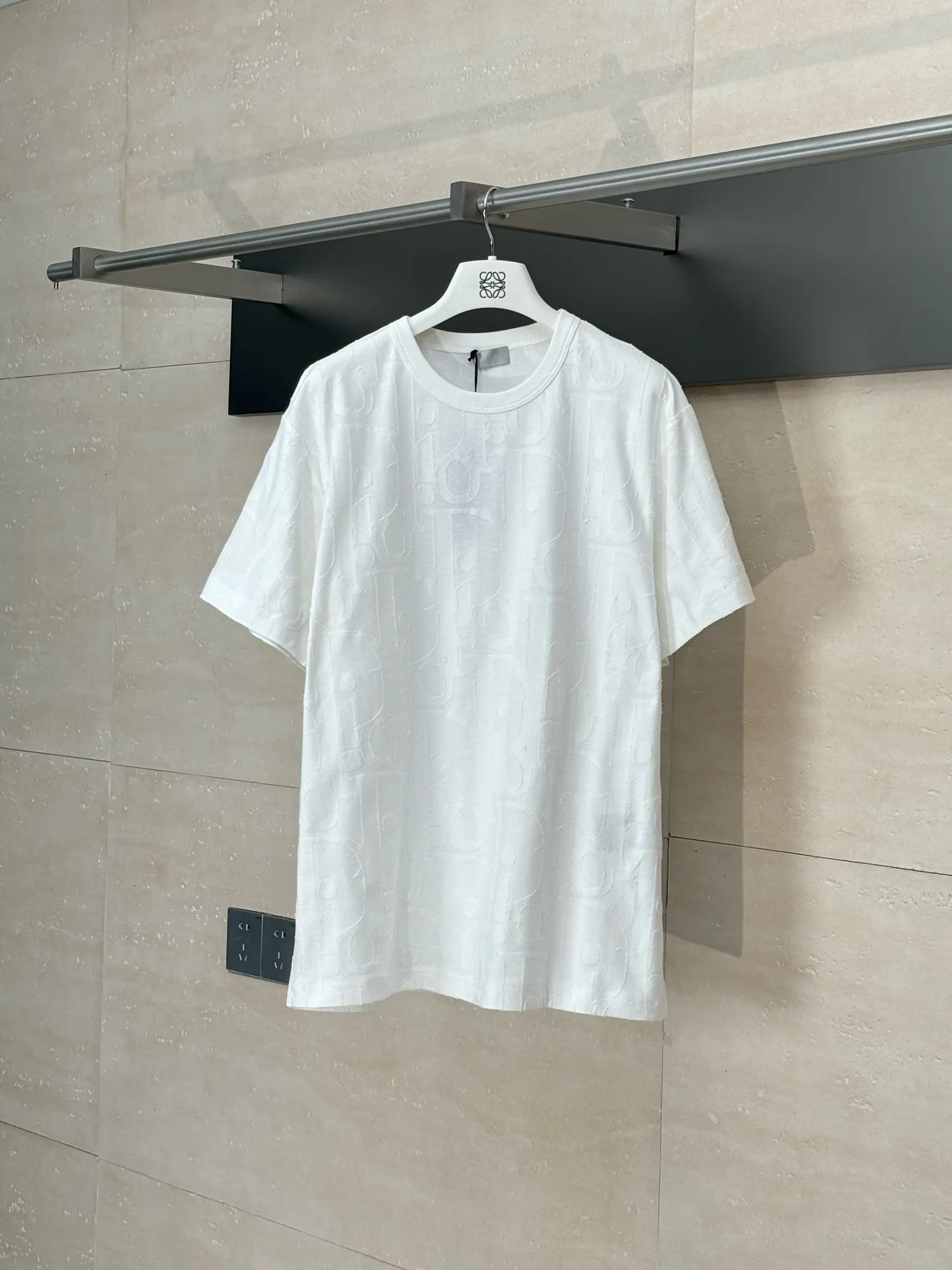 🅿️296 Dio*/Dior 25Ss new line-cut jacquard round-neck short-sleeved T-shirt. Pure cotton plain weave fabric, woven with 32S double-ply pure cotton yarn. The fabric has high abrasion resistance while retaining the moisture absorption and breathability of pure cotton. The plain weave has a tight structure and a smooth surface, but it feels relatively stiff and supports the stiffness of the version. Jacquard pattern, line-cut jacquard technology, full-width Oblique jacquard pattern The relief effect is formed through the deep integration of full-width jacquard and shearing process. The jacquard structure provides a three-dimensional skeleton, and the shearing process strengthens the local texture. Electronic jacquard machine weaves complex patterns on the entire fabric, forming a three-dimensional concave and convex texture to achieve the integration of texture and pattern. The raised jacquard is directionally sheared to form a relief effect, enhancing the tactile level and visual contrast. Size: S/M/L/XL