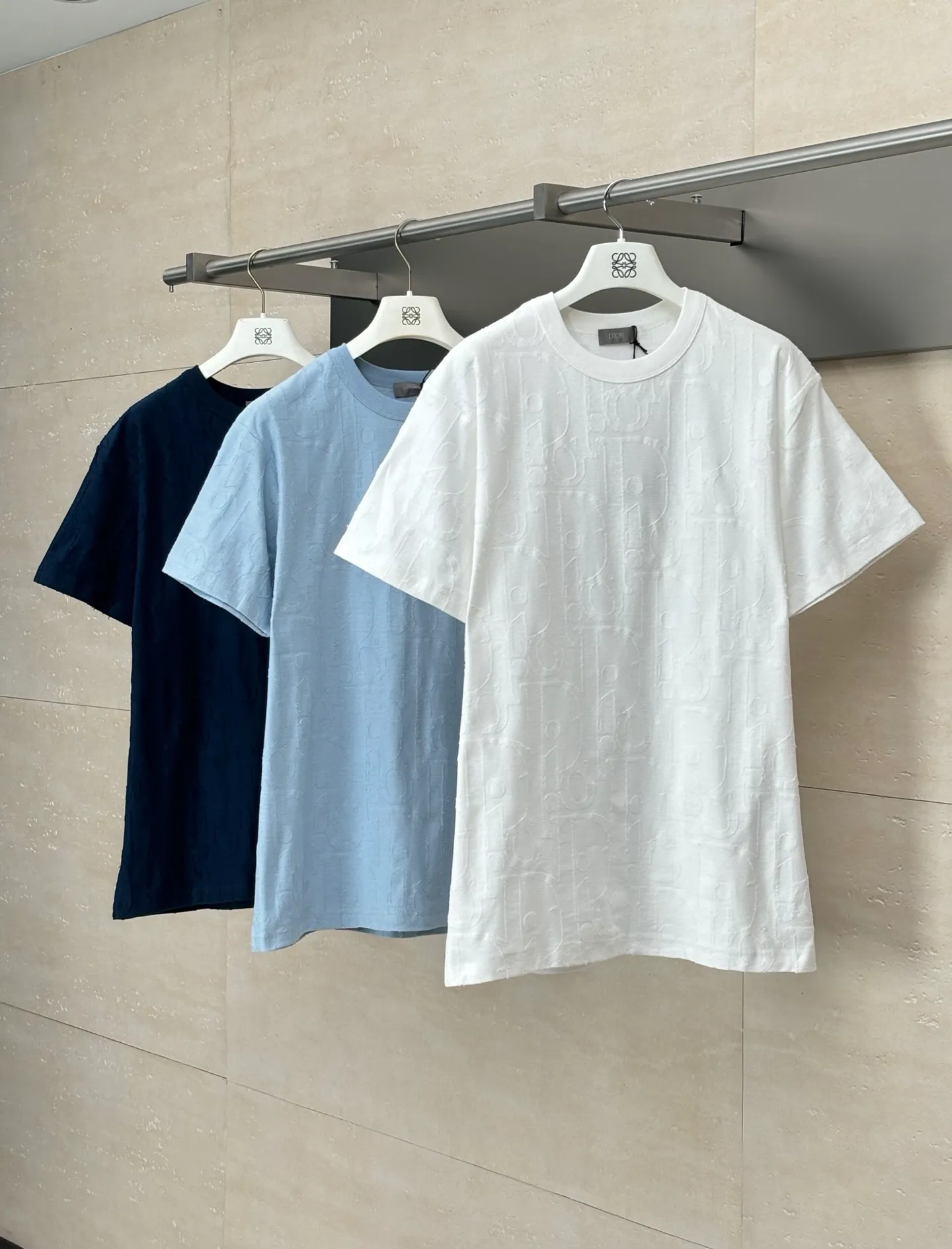 🅿️296 Dio*/Dior 25Ss new line-cut jacquard round-neck short-sleeved T-shirt. Pure cotton plain weave fabric, woven with 32S double-ply pure cotton yarn. The fabric has high abrasion resistance while retaining the moisture absorption and breathability of pure cotton. The plain weave has a tight structure and a smooth surface, but it feels relatively stiff and supports the stiffness of the version. Jacquard pattern, line-cut jacquard technology, full-width Oblique jacquard pattern The relief effect is formed through the deep integration of full-width jacquard and shearing process. The jacquard structure provides a three-dimensional skeleton, and the shearing process strengthens the local texture. Electronic jacquard machine weaves complex patterns on the entire fabric, forming a three-dimensional concave and convex texture to achieve the integration of texture and pattern. The raised jacquard is directionally sheared to form a relief effect, enhancing the tactile level and visual contrast. Size: S/M/L/XL
