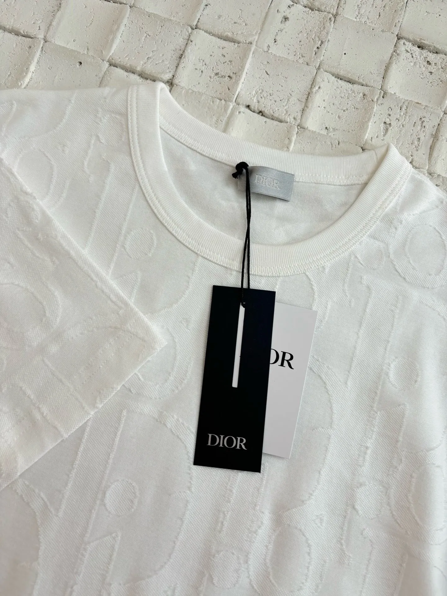 🅿️296 Dio*/Dior 25Ss new line-cut jacquard round-neck short-sleeved T-shirt. Pure cotton plain weave fabric, woven with 32S double-ply pure cotton yarn. The fabric has high abrasion resistance while retaining the moisture absorption and breathability of pure cotton. The plain weave has a tight structure and a smooth surface, but it feels relatively stiff and supports the stiffness of the version. Jacquard pattern, line-cut jacquard technology, full-width Oblique jacquard pattern The relief effect is formed through the deep integration of full-width jacquard and shearing process. The jacquard structure provides a three-dimensional skeleton, and the shearing process strengthens the local texture. Electronic jacquard machine weaves complex patterns on the entire fabric, forming a three-dimensional concave and convex texture to achieve the integration of texture and pattern. The raised jacquard is directionally sheared to form a relief effect, enhancing the tactile level and visual contrast. Size: S/M/L/XL