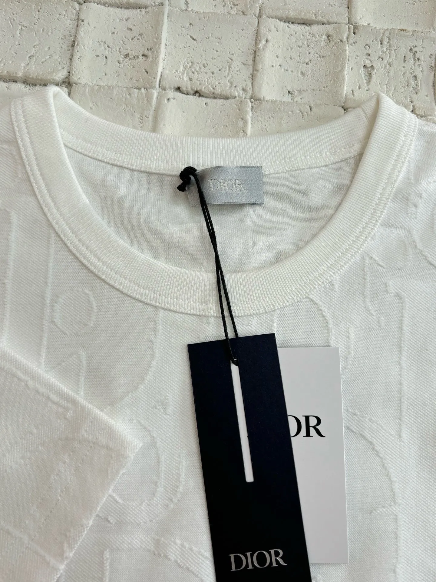 🅿️296 Dio*/Dior 25Ss new line-cut jacquard round-neck short-sleeved T-shirt. Pure cotton plain weave fabric, woven with 32S double-ply pure cotton yarn. The fabric has high abrasion resistance while retaining the moisture absorption and breathability of pure cotton. The plain weave has a tight structure and a smooth surface, but it feels relatively stiff and supports the stiffness of the version. Jacquard pattern, line-cut jacquard technology, full-width Oblique jacquard pattern The relief effect is formed through the deep integration of full-width jacquard and shearing process. The jacquard structure provides a three-dimensional skeleton, and the shearing process strengthens the local texture. Electronic jacquard machine weaves complex patterns on the entire fabric, forming a three-dimensional concave and convex texture to achieve the integration of texture and pattern. The raised jacquard is directionally sheared to form a relief effect, enhancing the tactile level and visual contrast. Size: S/M/L/XL