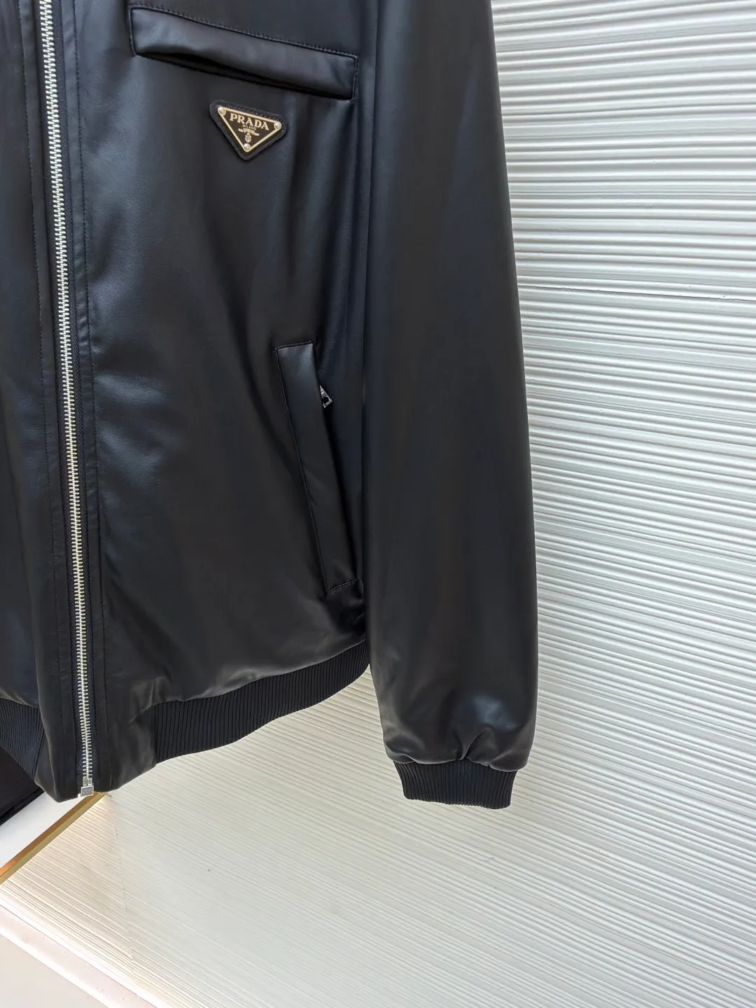 Prada reversible leather plain jacket ●Item number: 1681168-C65 ●Fabric: Leather lambskin fabric ●Technology: Ergonomic three-dimensional cutting ●Color: black ●Version: Fitted version ●Weight: about 970 grams ●Size: 46-48-50-52 ●Description: Customized Leather lambskin and rhyme-hole silky plain fabric, natural texture, natural luster, comfortable and close to the skin Double-sided charm, one garment for multiple enjoyments. On one side, the distinctive leather shows the noble texture, while on the other side, the simple plain grain interprets the low-key connotation. Clean lines and simple textures exude a sense of luxury from the inside out. The iconic enameled triangular metal logos are respectively embellished to highlight the elegance and nobility of the brand. It is highly recognizable. The two-sided transformation is wonderful and reflects each other. It unlocks a new dimension of fashion and uses imported infrared machines to locate the "Prada triangle logo" for more accurate positioning. Firm stone, ergonomic three-dimensional cutting, return to traditional craftsmanship through segmentation, folding, shrinking, and stretching techniques. The so-called slow work produces fine work, which is the respect for the material and the pursuit of feel. The workmanship is complex and tedious. Slow timeliness and high loss. The template machine opens the bag. The preset template guides the position, shape and size of the bag. The accuracy ensures the quality of the bag opening effect. The overall wiring is straight and delicate, the fabric is comfortable and soft, and the color is consistent without color difference. It can be matched with the same style to create a fashionable look and control various occasions. Customized accessories, complete with three standards, same style for men and women!