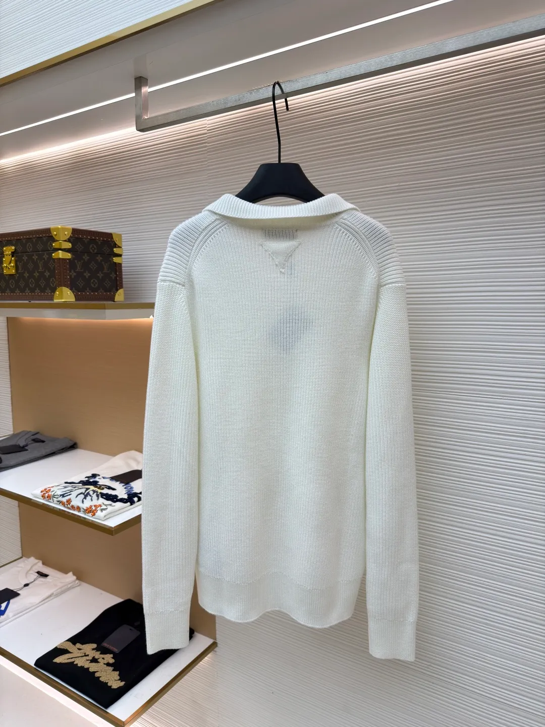 PRADA triangle logo seagull collar knitted sweater ●Item number: 1681464-A75 ●Fabric: 100% cotton ●Technology: knitted ●Color: white ●Version: Fitted version ●Weight: about 820 grams ●Size: S-M-L-XL ●Description: This sweater uses Polo collar knitting technology, with a crisp and stylish neckline, blending leisure and sophistication. Using thick needle texture weaving technology, the body texture is clear and rich in texture, creating a retro and simple style. In terms of details, the precise splicing process of the collar and placket ensures neat and natural stitching, ensuring the neatness of the silhouette; the rib knitting process of the cuffs and hem has moderate elasticity, which not only fits the body shape but also enhances the comfort of wearing. Made of high-quality knitted fabric and finely woven, it is skin-friendly, breathable and has a crisp silhouette. From the design of the neckline to the presentation of texture, every craftsmanship reflects the pursuit of classic styles and delicate workmanship. It is a knitted item that combines daily practicality with style. The overall wiring is straight and delicate, the fabric is comfortable and soft, and the color is consistent without color difference. It can be matched with the same style to create a fashionable look and control various occasions. Customized accessories, complete with three standards, same style for men and women!