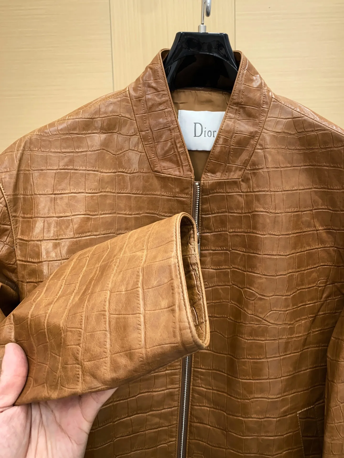 🅿️3100 DIOR Dior's new men's sheepskin jacket for autumn and winter 2025, reshaping autumn and winter style. On the fashion stage, Dior has always been the trend leader. In the autumn and winter of 2025, Dior's new men's sheepskin jacket makes a shocking debut, bringing the ultimate experience to men who pursue quality and style.   The jacket is made of imported brown sheepskin. Its unique color is deep and full of charm, like an elegant poem that has accumulated over time, highlighting the mature and stable temperament of men. This high-quality sheepskin not only looks charming, but also feels soft and delicate. Every time you touch it, you can feel the luxurious texture brought by the top material. It also has good breathability and wear resistance, ensuring that it is comfortable to wear in various occasions.   The design with crocodile print all over the body is the finishing touch. The crocodile pattern symbolizes strength and wildness, injecting unique fashion tension into the jacket, making the wearer stand out from the crowd. Every texture has been carefully suppressed, delicate and clear, showing a lifelike three-dimensional effect, interpreting Dior's persistent pursuit of craftsmanship.   The short version is a precise grasp of modern fashion. It breaks the traditional constraints and cleverly optimizes body proportions. Even men with average figures can instantly have a tall and straight posture when wearing it, showing a neat and capable temperament. Whether it is paired with a simple white T-shirt and jeans for casual daily use, or worn with a shirt and trousers for a business event, it can be perfectly adapted and can easily handle various occasions.   The new products of the season have arrived in the store. We sincerely invite you to try them out and experience the unique charm of Dior's new 2025 autumn and winter men's sheepskin jackets.  Code number: 48-56