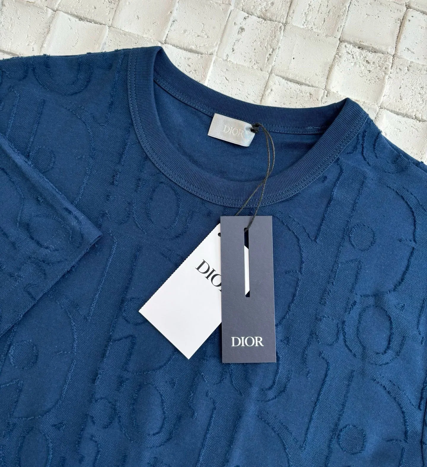 🅿️296 Dio*/Dior 25Ss new line-cut jacquard round-neck short-sleeved T-shirt. Pure cotton plain weave fabric, woven with 32S double-ply pure cotton yarn. The fabric has high abrasion resistance while retaining the moisture absorption and breathability of pure cotton. The plain weave has a tight structure and a smooth surface, but it feels relatively stiff and supports the stiffness of the version. Jacquard pattern, line-cut jacquard technology, full-width Oblique jacquard pattern The relief effect is formed through the deep integration of full-width jacquard and shearing process. The jacquard structure provides a three-dimensional skeleton, and the shearing process strengthens the local texture. Electronic jacquard machine weaves complex patterns on the entire fabric, forming a three-dimensional concave and convex texture to achieve the integration of texture and pattern. The raised jacquard is directionally sheared to form a relief effect, enhancing the tactile level and visual contrast. Size: S/M/L/XL